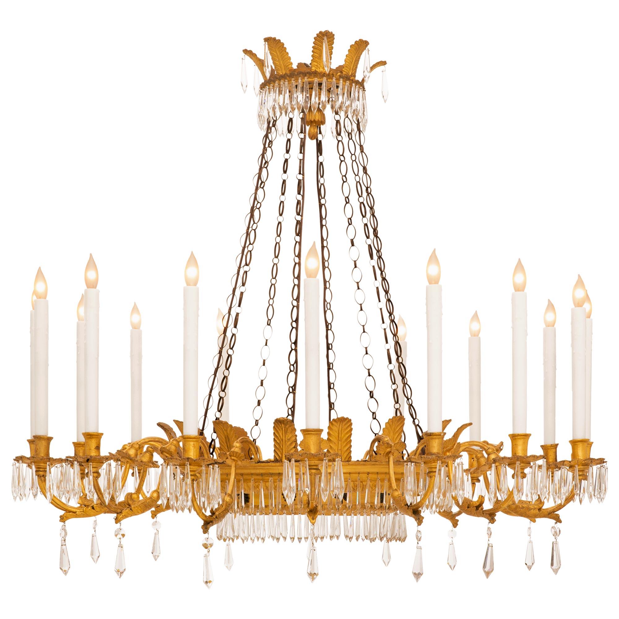 Magnifique et très élégant lustre italien d'époque Louis XVI en bois doré et cristal. Le lustre à seize branches est centré par un superbe dôme en cristal taillé et ajusté, orné d'exquis motifs floraux merveilleusement exécutés et d'un ensemble très