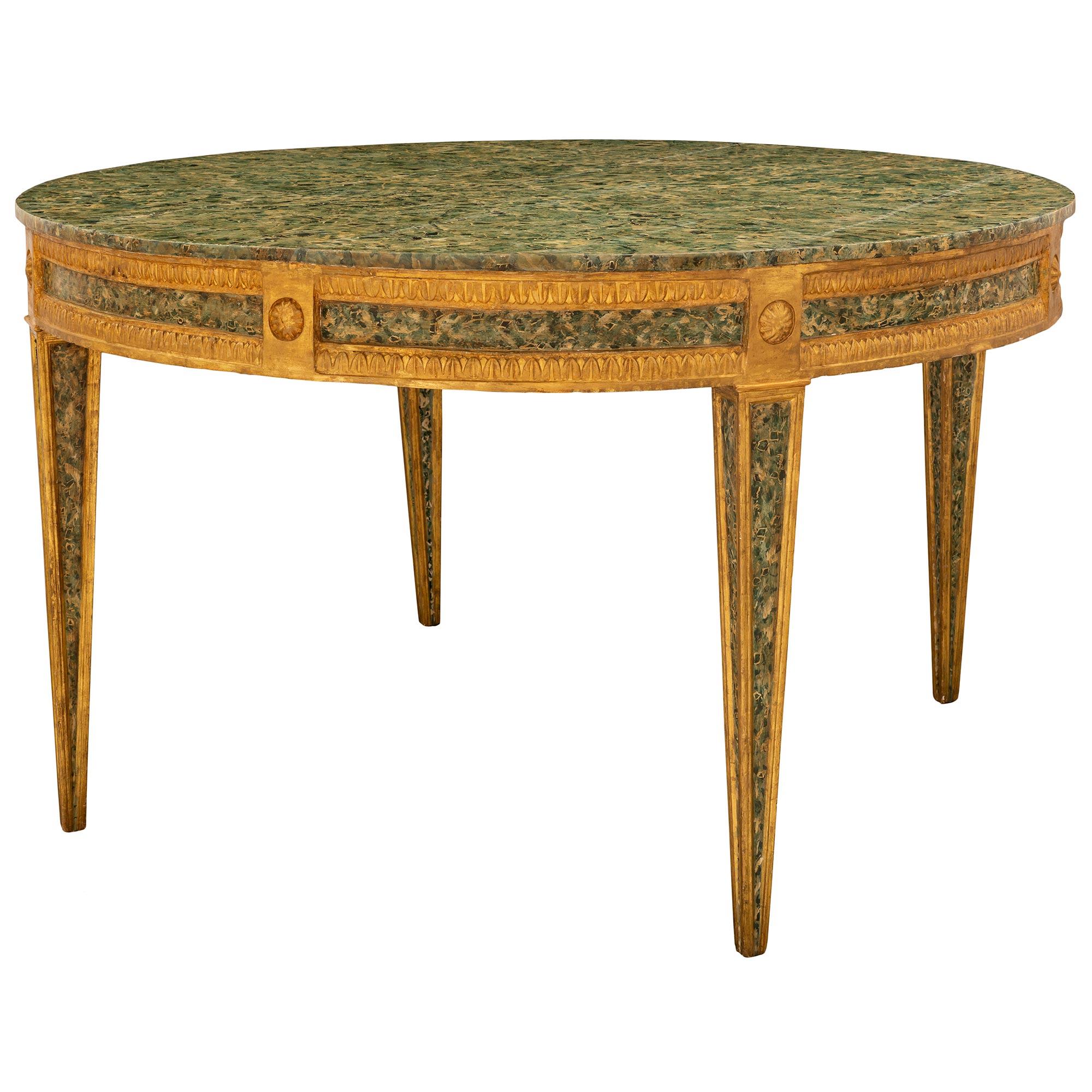 A sensational and exceptionally well executed Italian 18th century Louis XVI period giltwood and faux painted marble center table. The circular table is raised by impressive square tapered legs finished on all sides with beautiful recessed faux