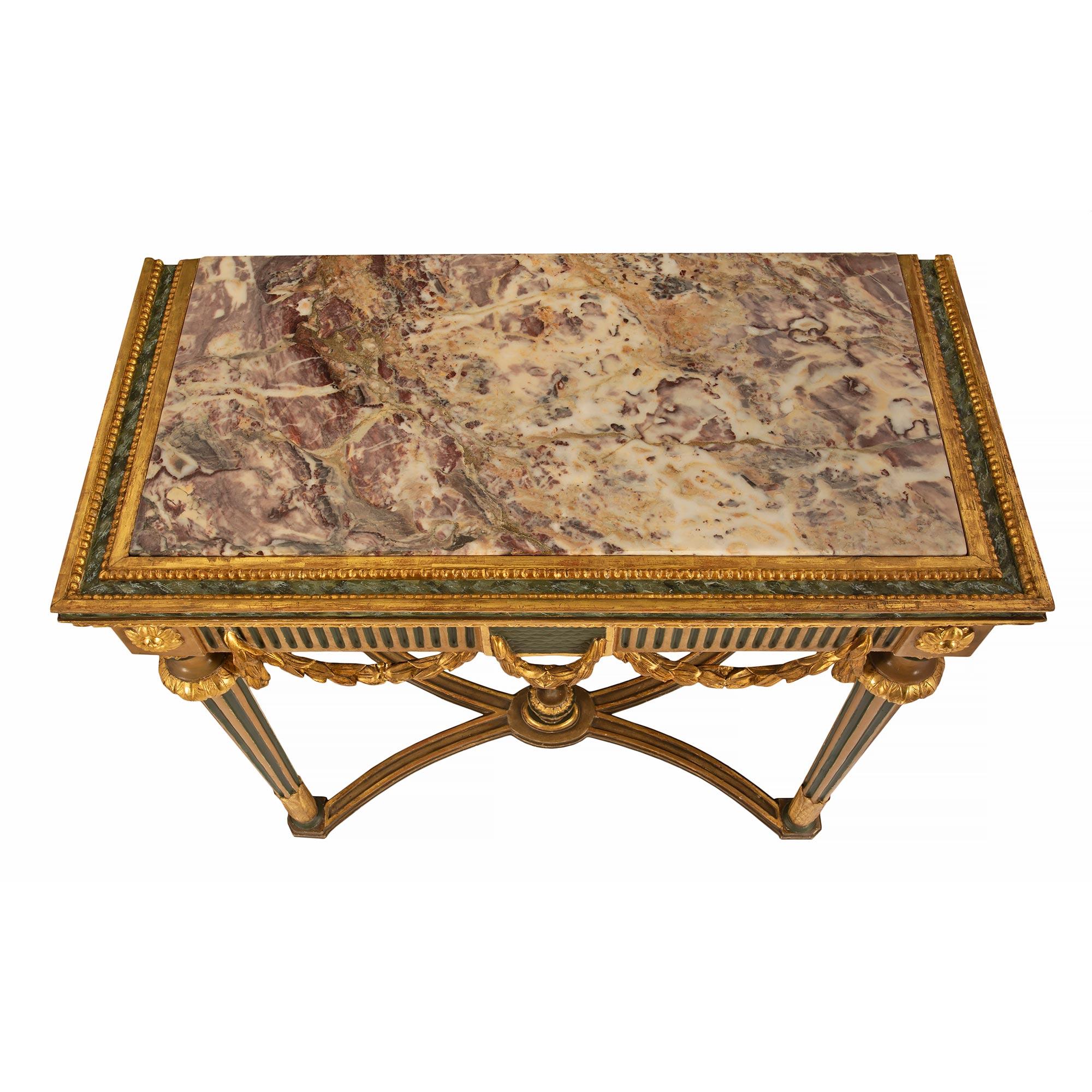 A beautiful and most decorative Italian 18th century Louis XVI period patinated, giltwood and Fleur de Pécher marble freestanding console. The console is raised by topie shaped feet with patinated tapered fluted legs accented by giltwood acanthus
