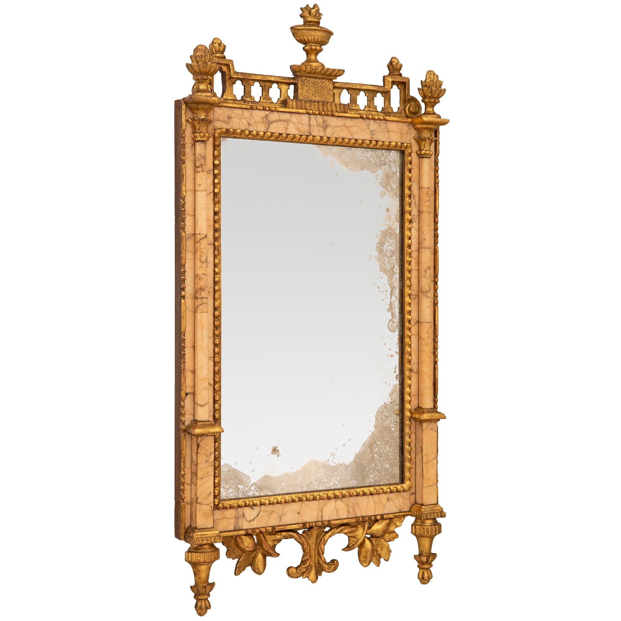 Très élégant et unique miroir en bois doré et marbre Lumachella Carnina O Carnacina d'époque Louis XVI. Ce miroir rectangulaire, qui a conservé toute sa glace, son marbre et sa dorure d'origine, est surélevé par deux supports en bois doré en forme