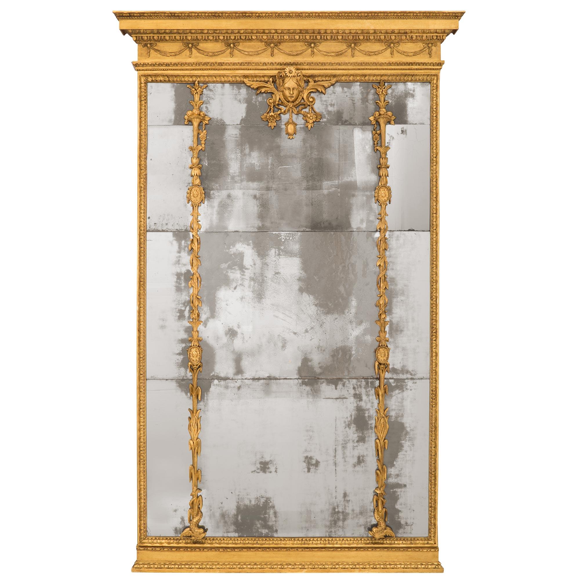 Miroir en bois doré italien du XVIIIe siècle, de taille monumentale, d'époque Louis XVI. Le miroir a conservé toutes ses plaques de miroir d'origine dans une belle bordure de feuillage marbré. La base présente également un fin motif moucheté avec