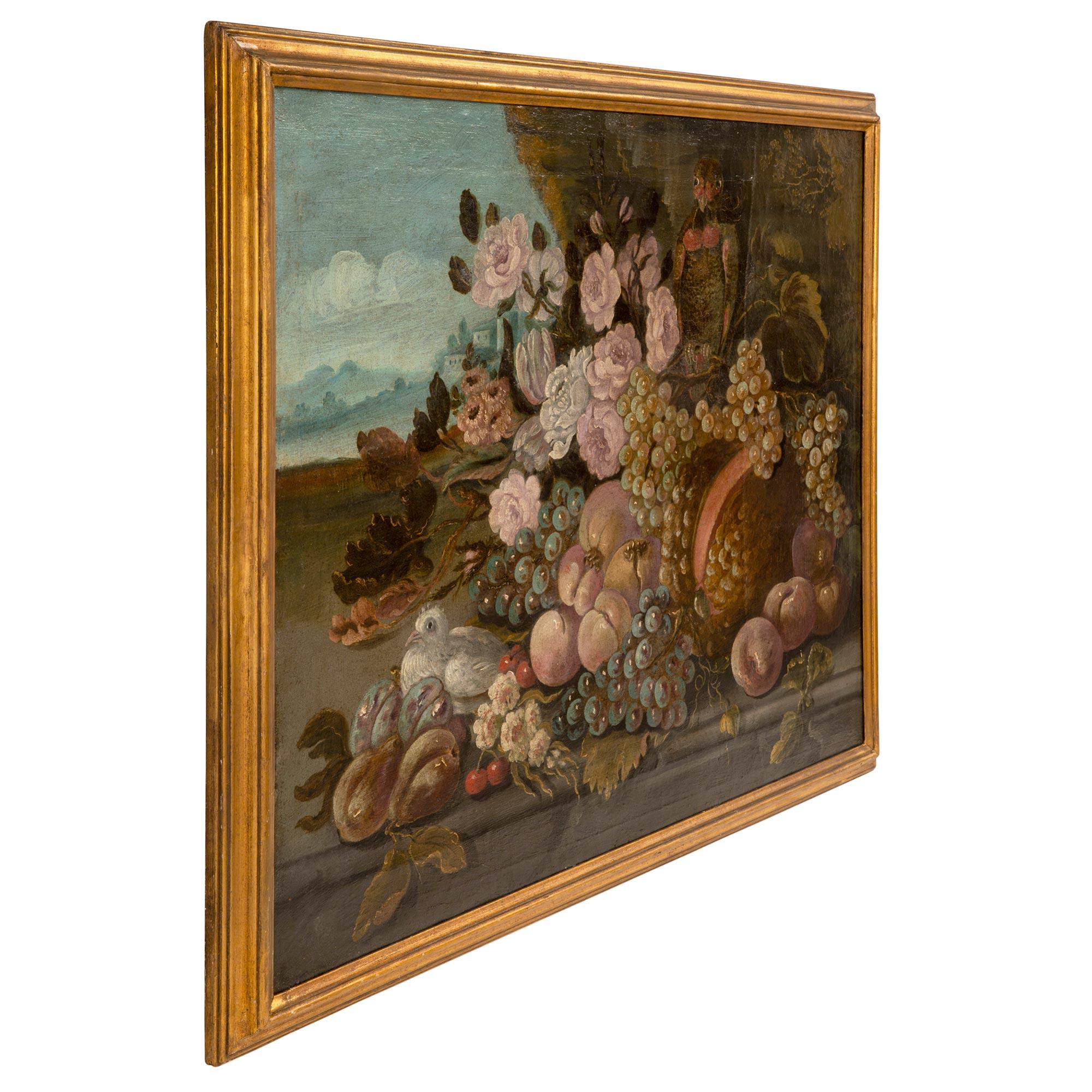 A beautiful Italian 18th century Louis XVI period oil on canvas still life painting. The painting depicts a lovely colorful abundance of wonderfully executed fruit and flowers set outside in the beautiful Italian countryside. There are charming