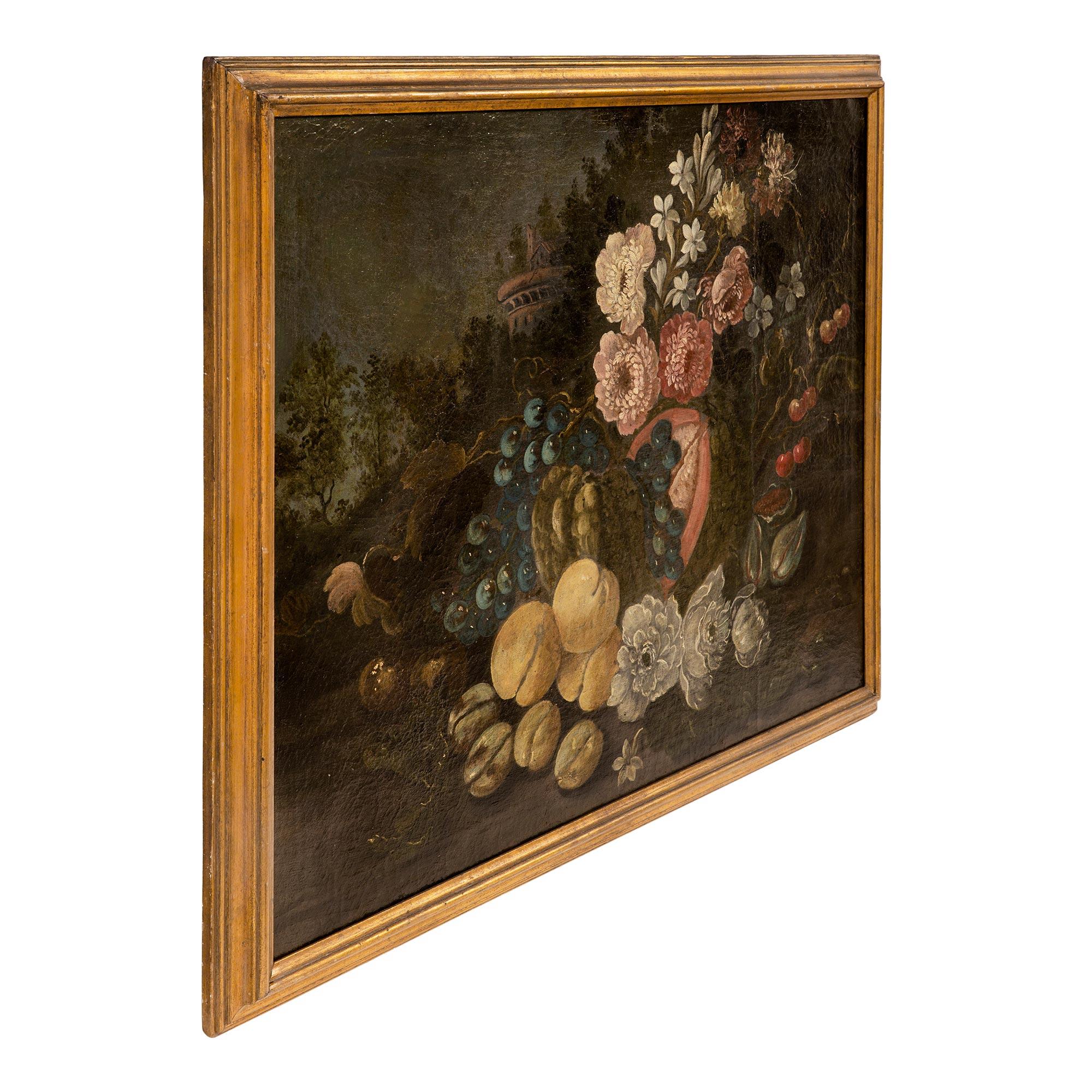 A beautiful Italian 18th Century Louis XVI period oil on canvas still life painting. The painting depicts a lovely colorful abundance of wonderfully executed fruit and flowers set outside in the beautiful Italian countryside with an elegant villa in