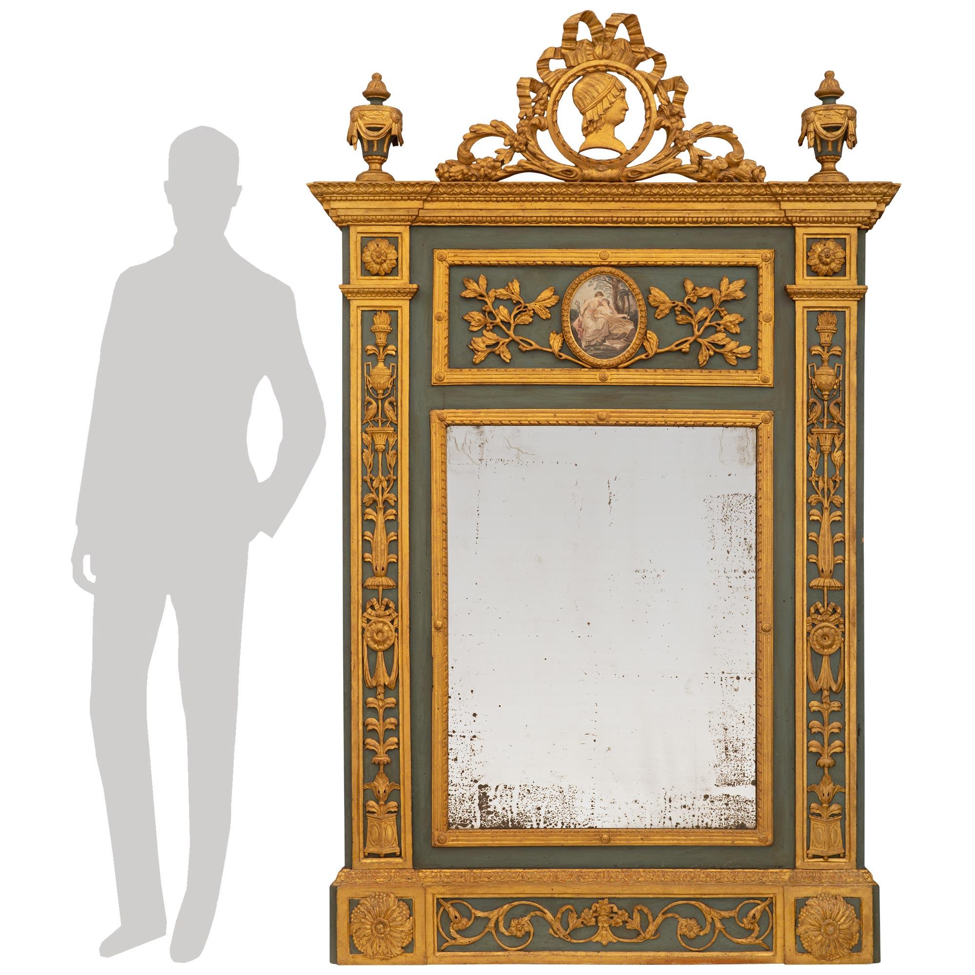 An elegant Italian 18th century Louis XVI period patinated and giltwood Trumeau. The Trumeau is raised on a straight giltwood base with two large giltwood rosettes at each side flanking a foliate rinceau style pattern below a carved acanthus leaf