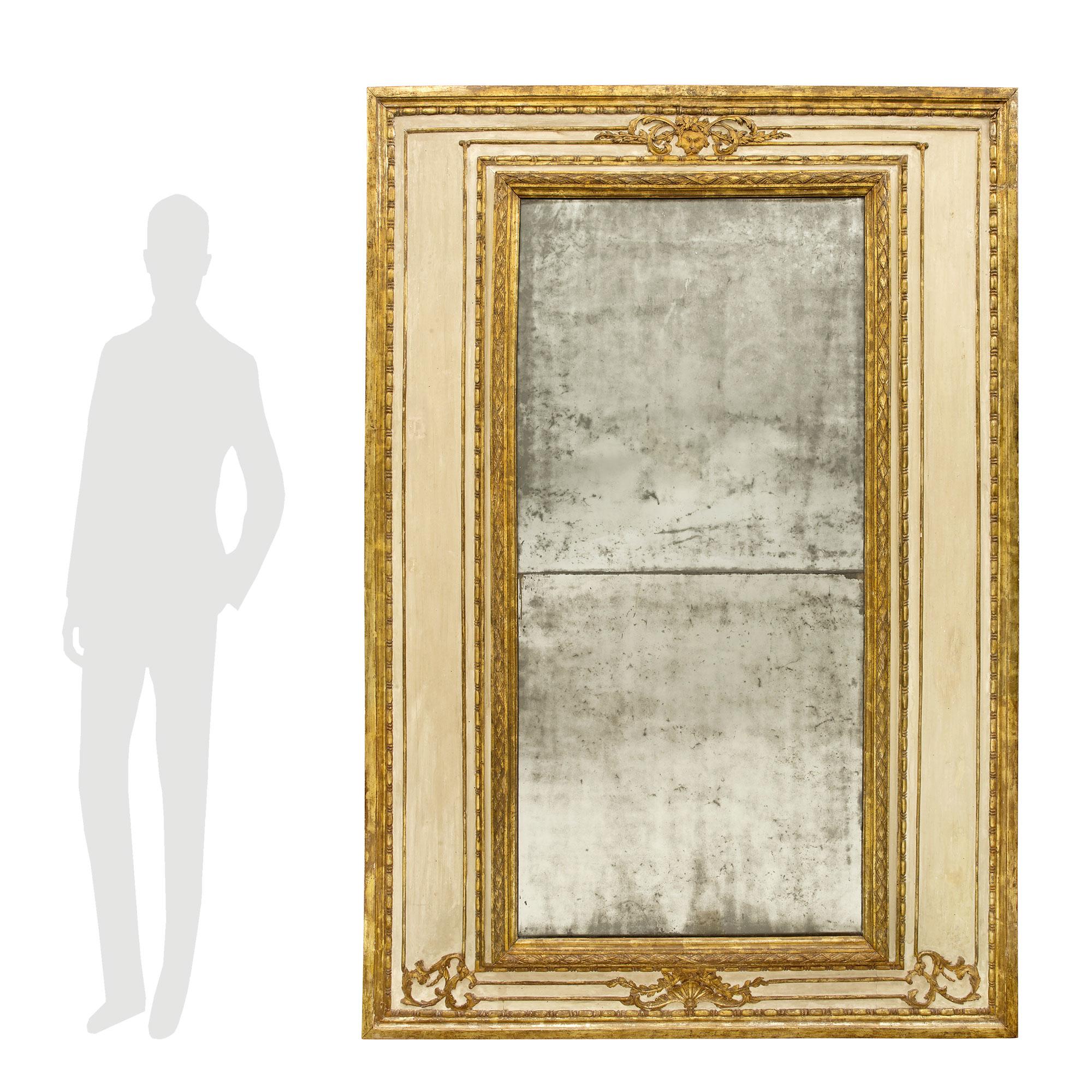 Un beau et grand miroir italien du 18ème siècle d'époque Louis XVI patiné et mecca. Les plaques de miroir d'origine sont encadrées d'une fine bordure mouchetée en forme de mecca et d'une bande en forme de losange feuillagé. En tête, d'élégants