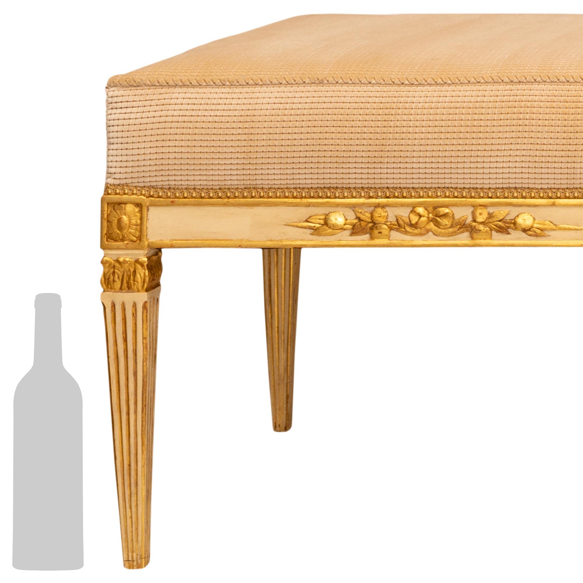 Un'elegante panca italiana del XVIII secolo in legno patinato e Wood Wood di grandi dimensioni. Questa bellissima panca, decorata su tre lati, è patinata con una finitura bianco sporco e accenti di legno dorato. La panca è sollevata da otto gambe