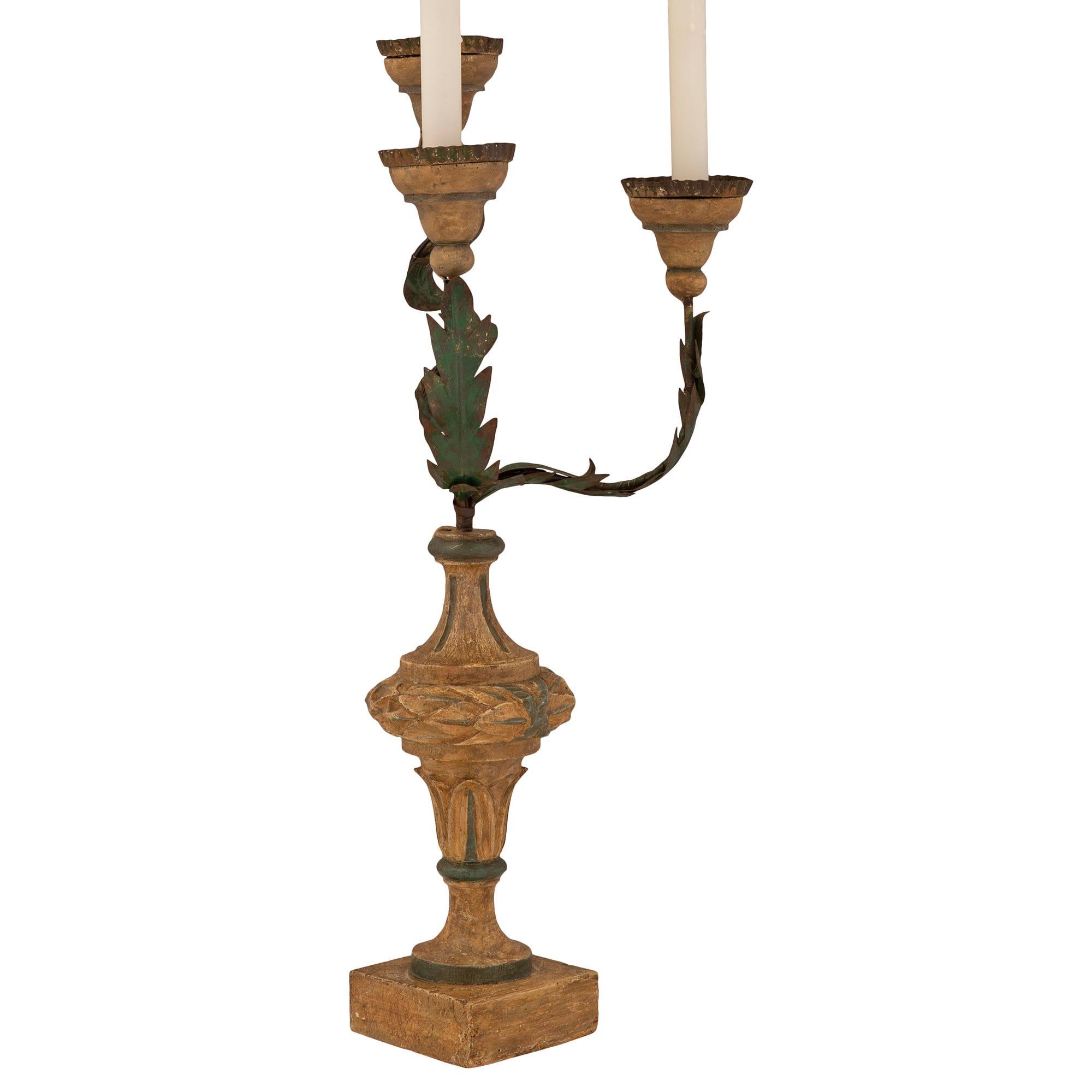 Un charmant et très décoratif candélabre italien d'époque Louis XVI du 18ème siècle en bois patiné et tole. Chaque lampe à trois bras est surélevée par une base carrée sous l'élégant et très décoratif corps en forme de topie avec un support en forme