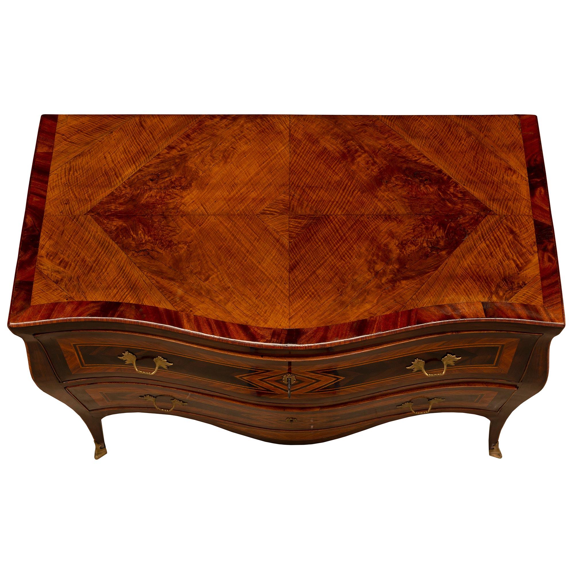 An outstanding Italian 18th century Louis XV period Rosewood, Kingwood, burl Walnut and bronze commode. The two drawer chest is raised by elegant cabriole legs with fine fitted bronze sabots. Above the beautiful deep arbalest shaped frieze is the