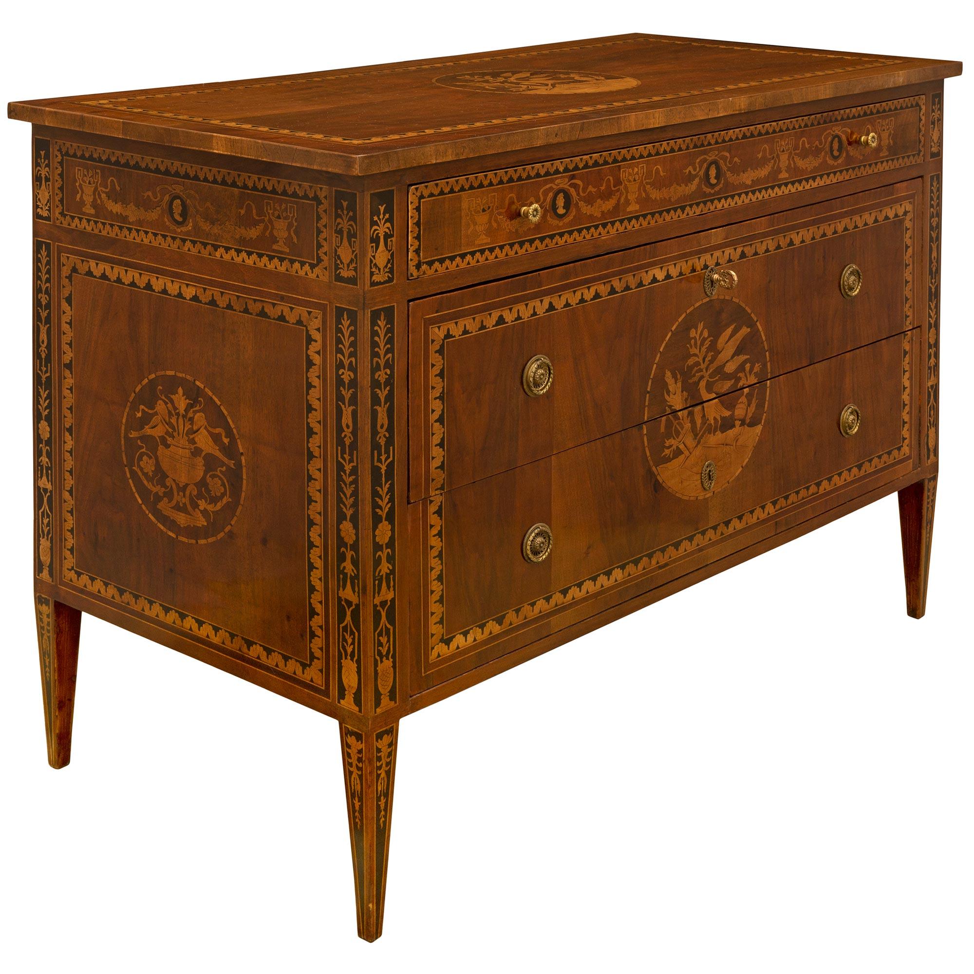 A very handsome Italian 18th century Louis XVI period walnut and tulipwood marquetry commode, in the manner of Maggiolini. The three drawer chest is raised on four square tapered legs with an intricate marquetry design that is repeated along with