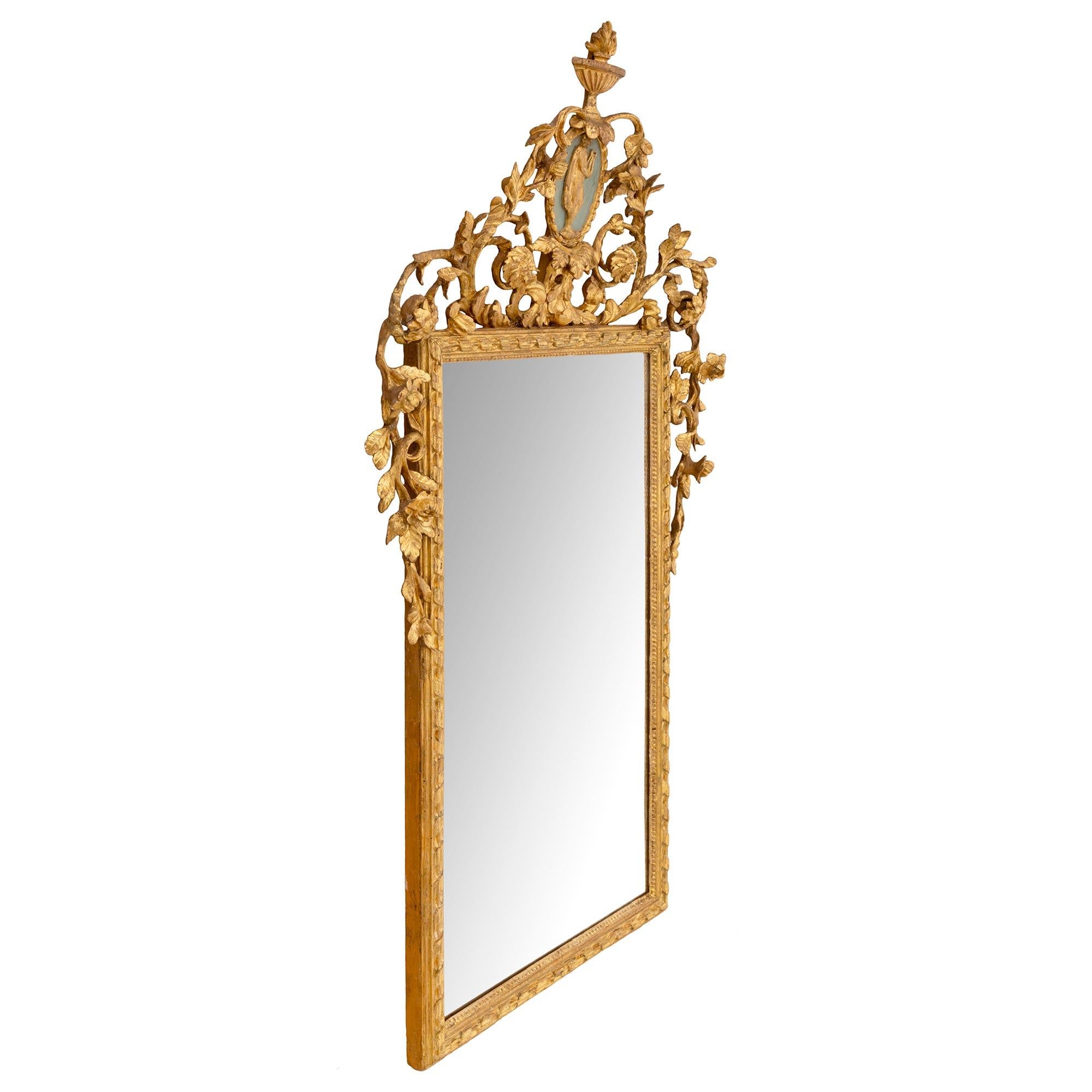 Un sensationnel miroir italien du 18ème siècle en bois doré de style Louis XVI. La plaque de miroir rectangulaire d'origine est encadrée d'une bordure en bois doré finement sculptée avec un joli ruban torsadé et un motif de perles. Au-dessus,