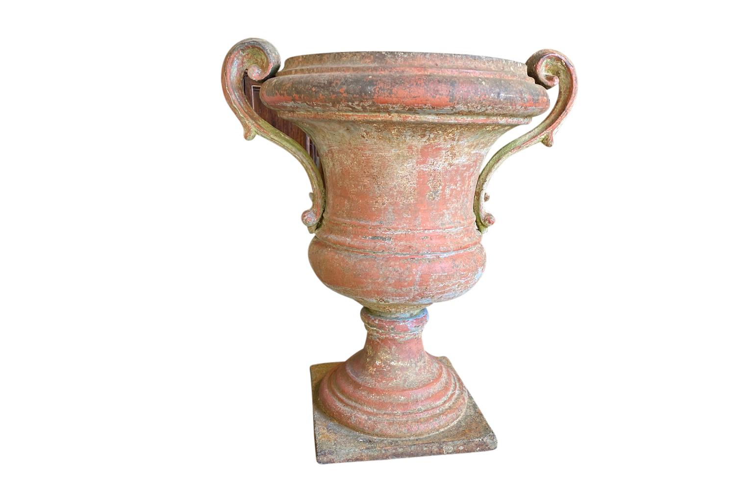 A stunning 18th century Medeci Urn from Florence, Italy. Beautifully cast in iron with a very beautiful finish in tones of sienna and light moss green. Wonderful minimalist lines with outstanding patina. Perfect for any interior or exterior.