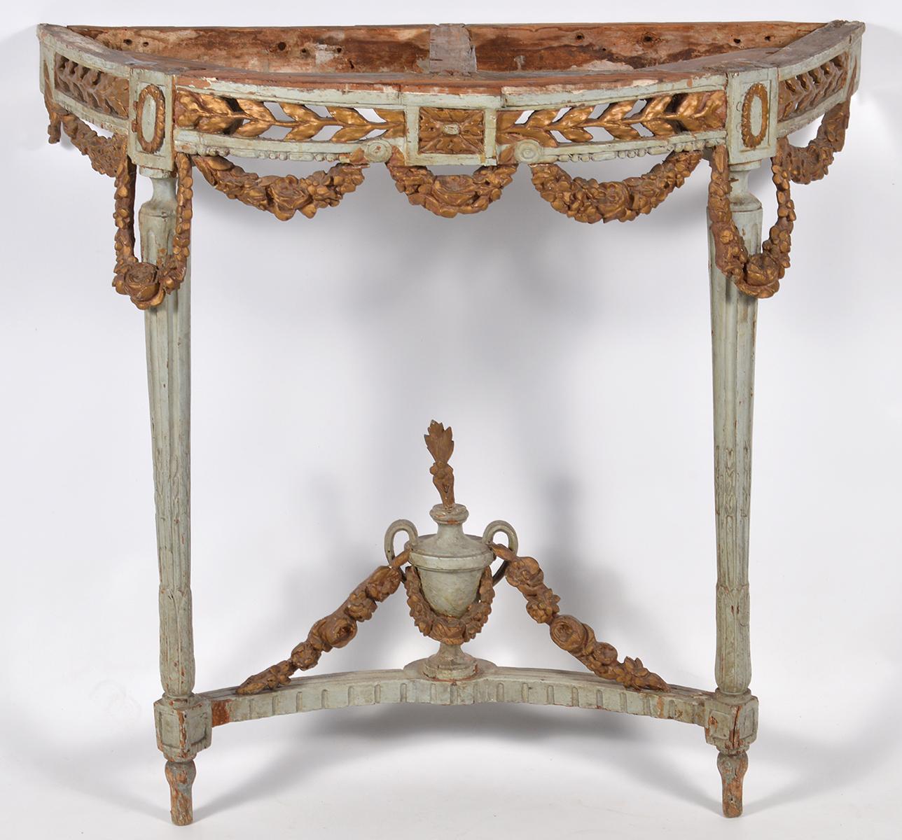 This wonderful Italian carved console table dates to the late 18th century and is fashioned in the French Louis XVI style of the period with openwork gilt wood frieze and carved garlands surmounting two circular reeded and tapering legs united by a