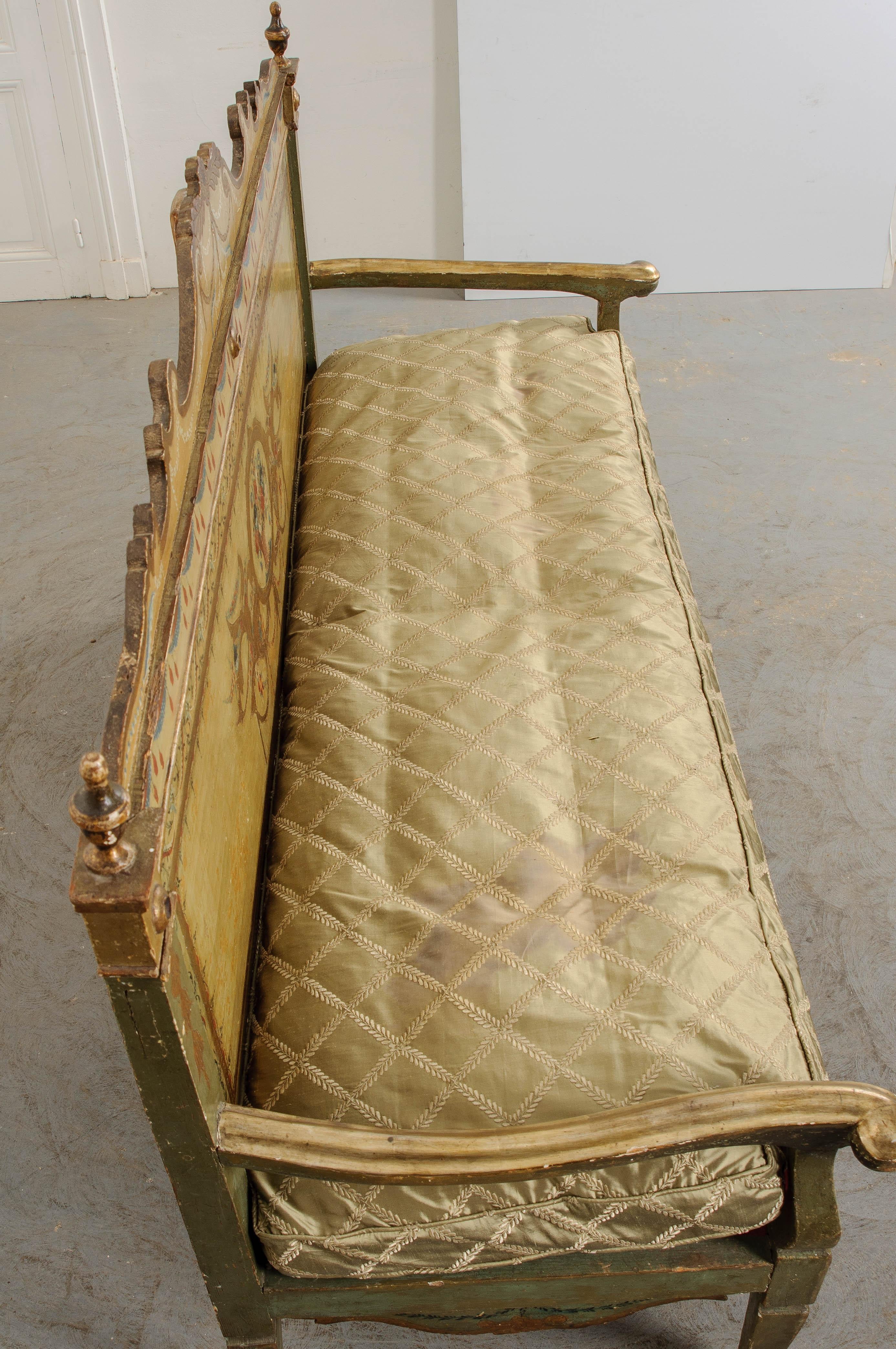 Masterfull artistic talent was employed to create this stunning Italian canape. The sofa’s back could be mistaken for a canvas, given the finely detailed artwork that graces its surface. A central cartouche encircles a sweet bouquet of potted