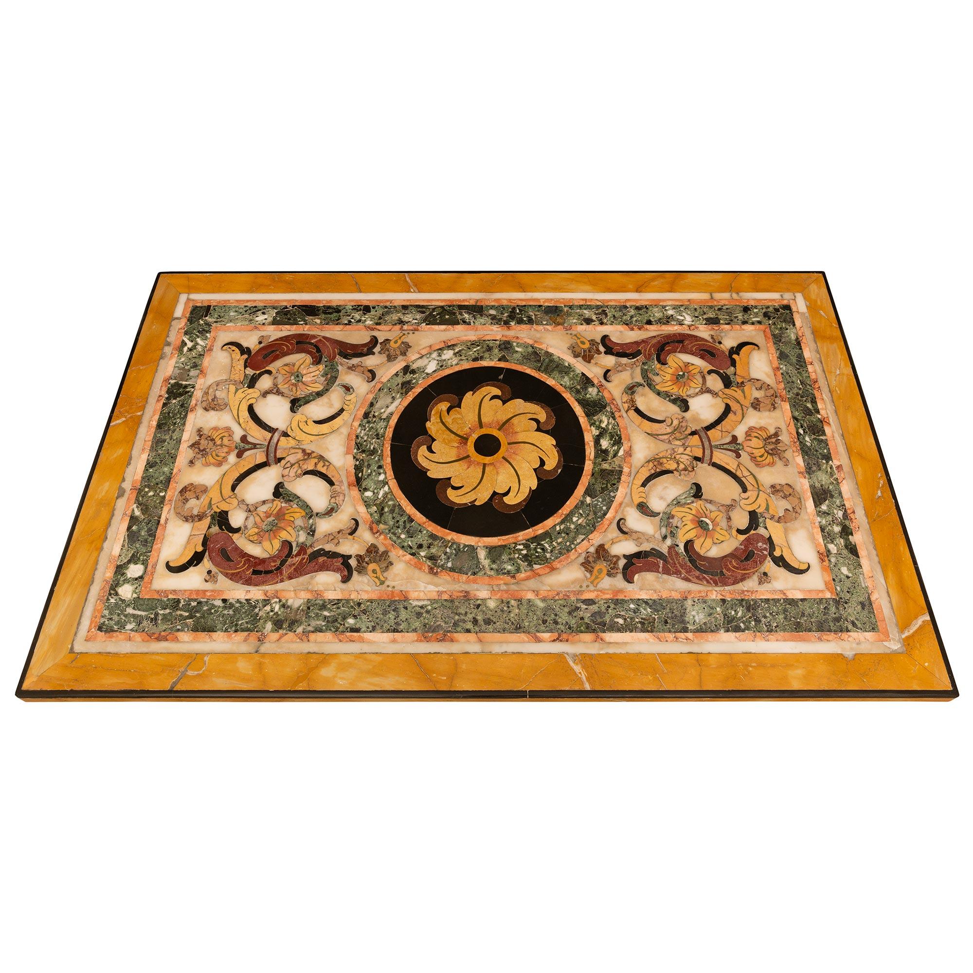 A most attractive Italian early 18th century Pietra Dura Marble, Wrought Iron and Brass coffee table. The most stunning Pietra Dura marble plateau is supported by a wonderful Wrought Iron base with two horseshoe shaped legs connect in the center by