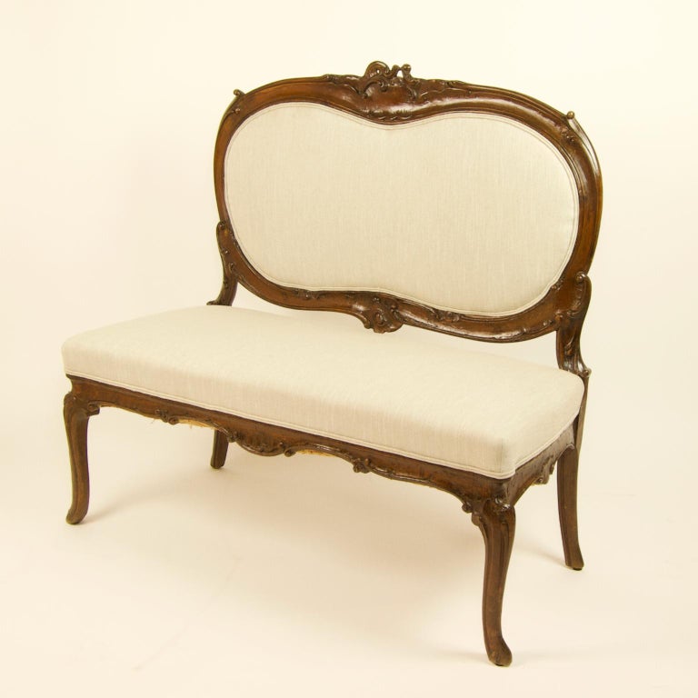 Italian 18th century rococo carved walnut sofa or canape

Standing on four cabriole legs with stylized foliage a carved rocaille shaped apron with a padded seat. The padded back with a carved wooden frame decorated with acanthus leaf scrolls and a