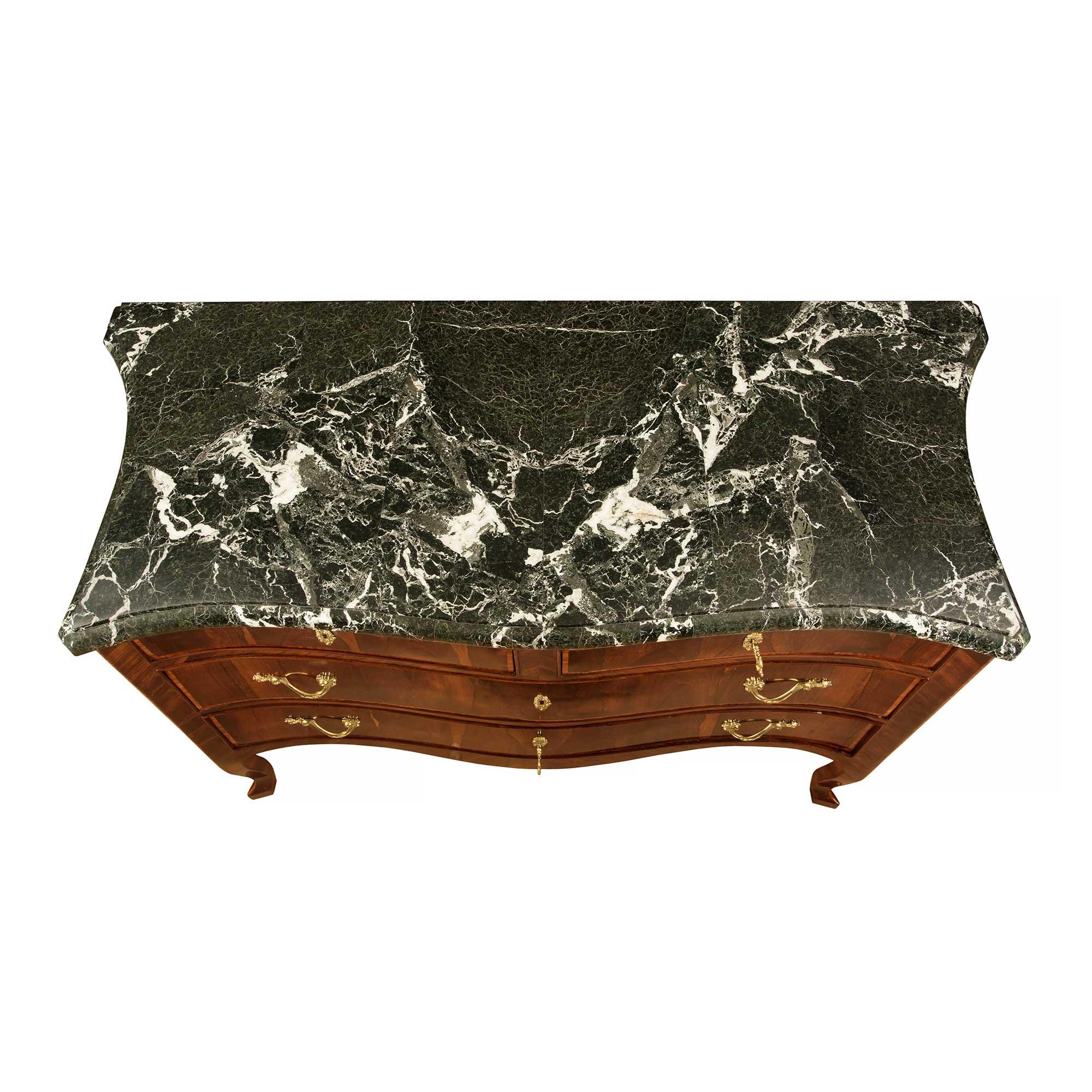 Una bella e unica commode a quattro cassetti in legno di palissandro e kingwood italiana del XVIII secolo. La cassapanca è sollevata da raffinate gambe cabriole che si estendono fino a un elegante fregio a forma di arbusto. I quattro cassetti