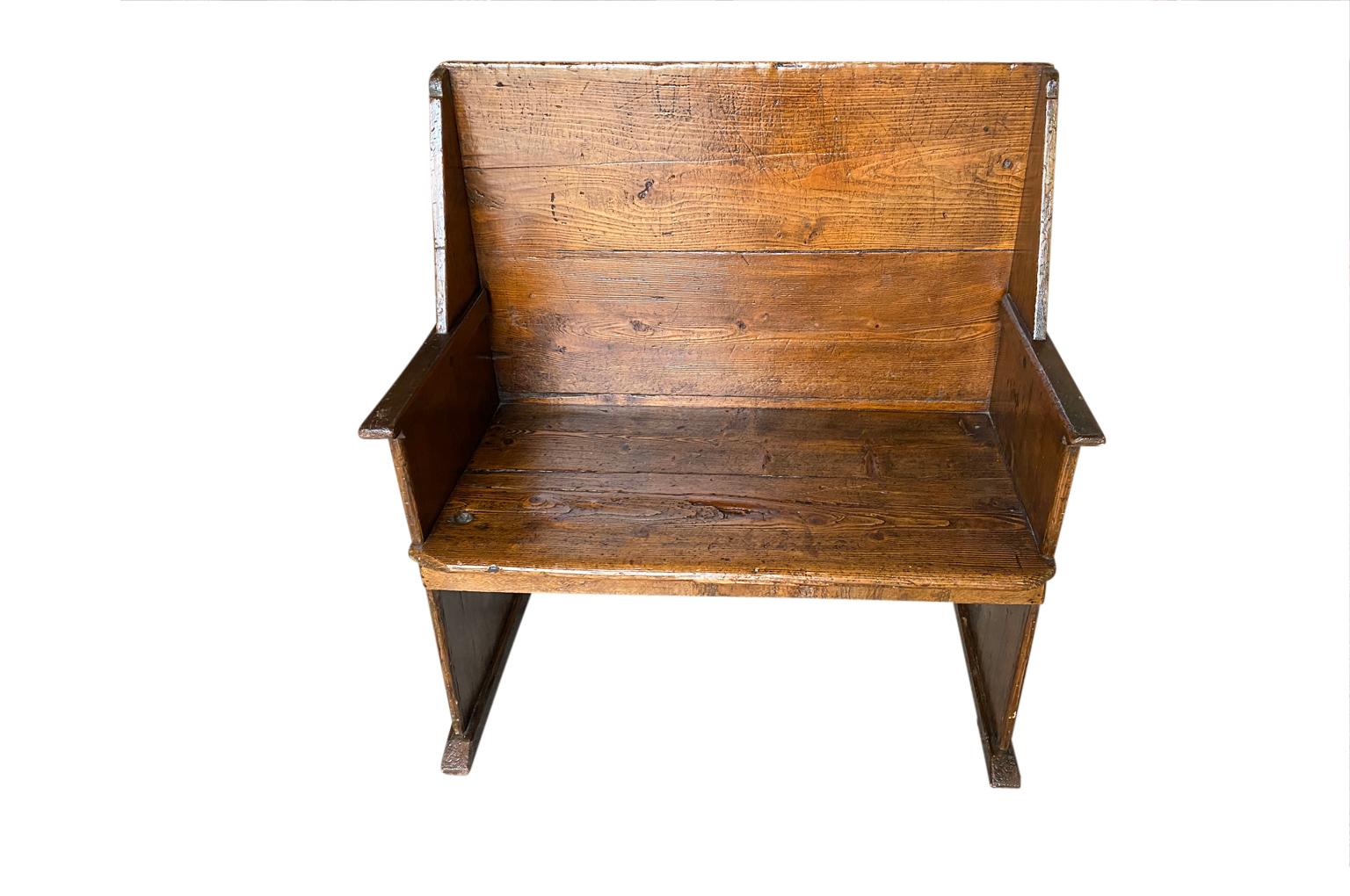 A very charming and primitive 18th century Bench from Northern Italy.  Soundly constructed from richly stained pine with a high back.  Wonderful patina.  A handsome accent piece.  The seat height is 18 3/4