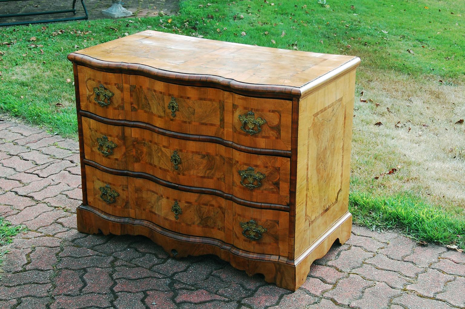 Italian serpentine shaped three drawer chest or commode with elaborate burl and heavily figured walnut parquetry inlay. The inlay covers the top, sides and front of this chest, making it quite fluid and strikingly lovely. This chest has a superb