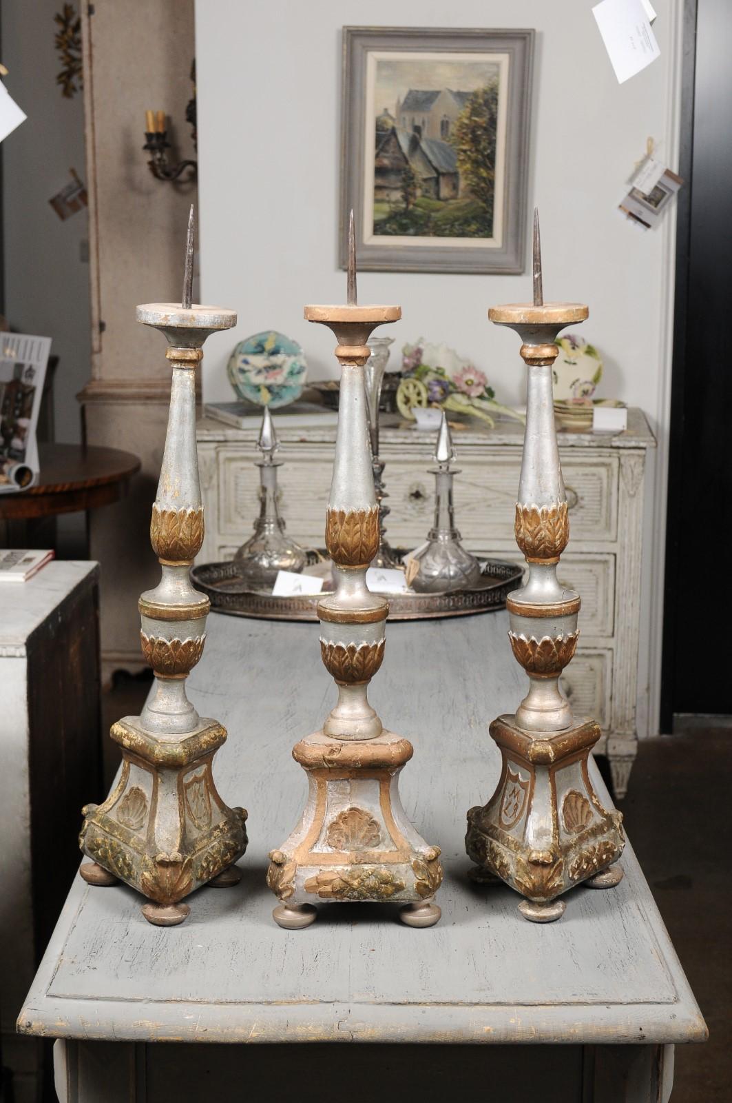 Three Italian silver gilt and painted candlesticks from the 18th century, priced and sold individually. Born in Italy during the 18th century, each of these three wooden candlesticks boasts a lovely silver gilt structure, adorned with painted