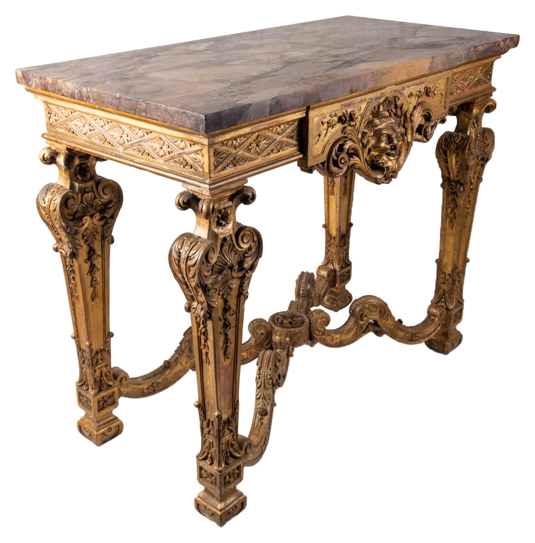 A good quality Italian 18th century style carved giltwood console table, having its original marble top, classical motif and mask decoration to the frieze, raised on four tapering legs each with carved scrolling design, united by a scrolling