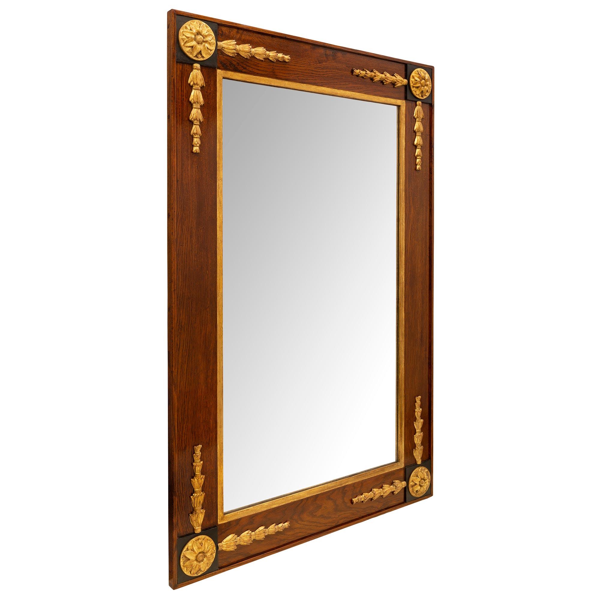 Un beau miroir italien du 18ème siècle, de style toscan, en noyer, bois fruitier ébénisé et bois doré. Le miroir central d'origine est entouré d'une fine bordure en bois doré et d'un magnifique cadre en noyer mettant en valeur le grain chaud du