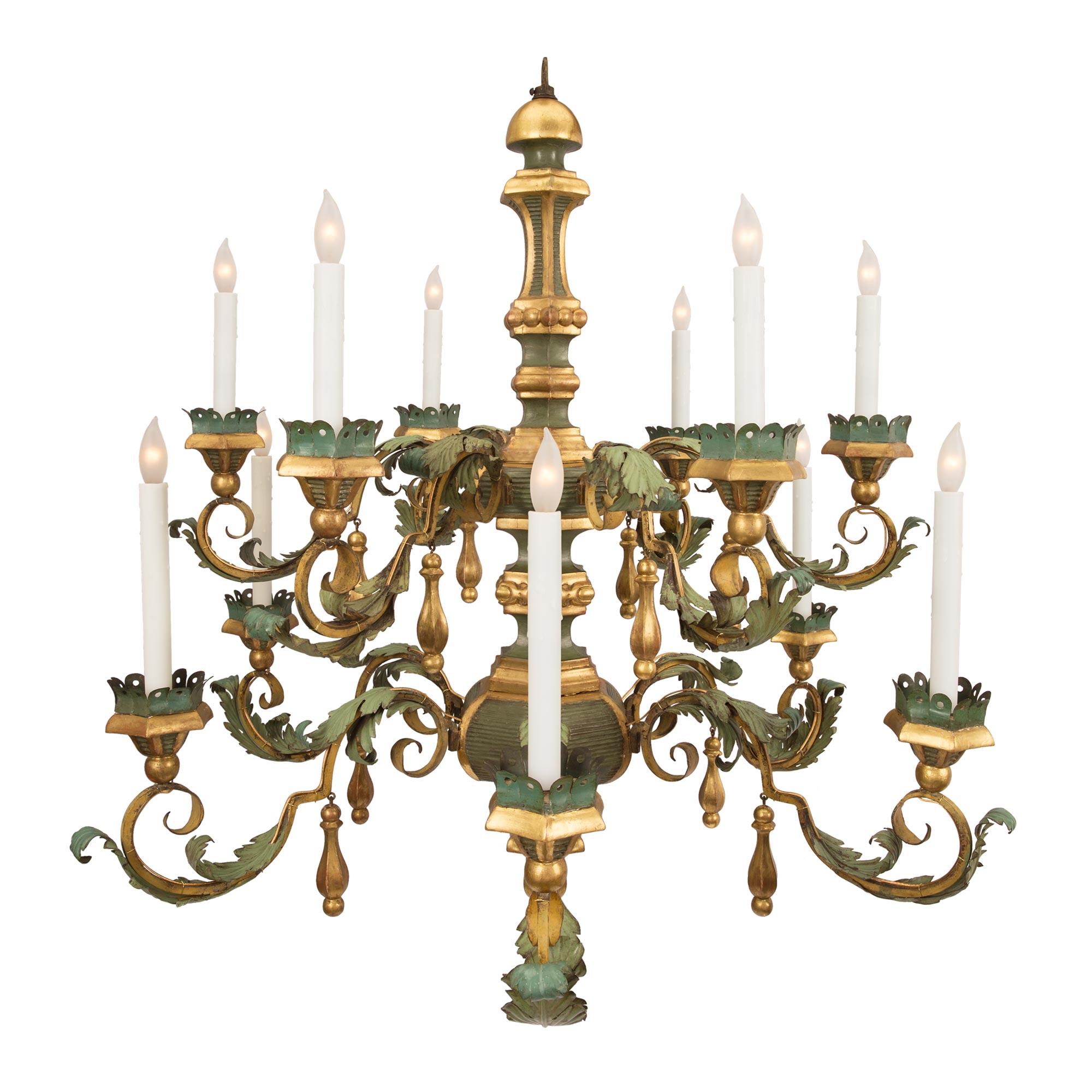 An exceptional and most unique Italian 18th century Tuscan twelve light patinated tole, giltwood and gilt iron chandelier. The chandelier is centered by a lovely inverted hexagonal giltwood finial below a fine horizontal fluted design. The unique