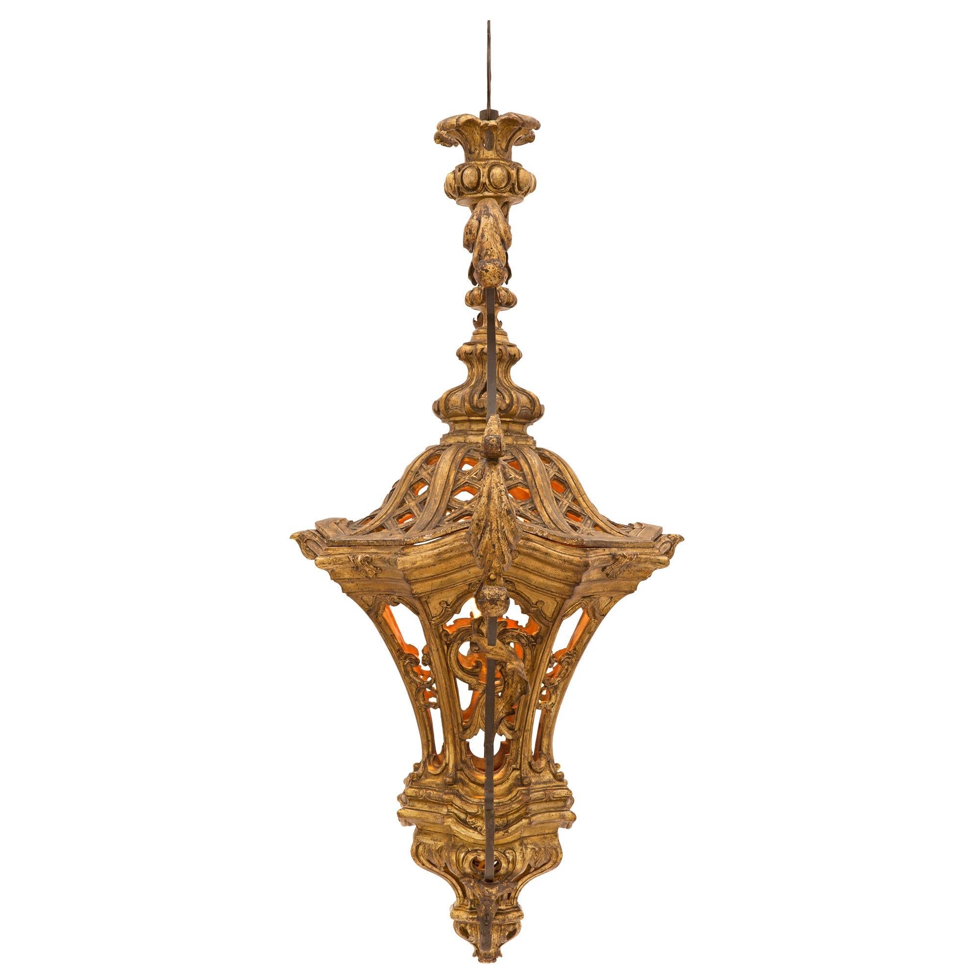 Une exquise et très unique lanterne italienne vénitienne du 18ème siècle en métal doré et fer forgé. La lanterne est centrée par un charmant fleuron richement sculpté sous l'impressionnant et très décoratif corps percé avec d'étonnants motifs