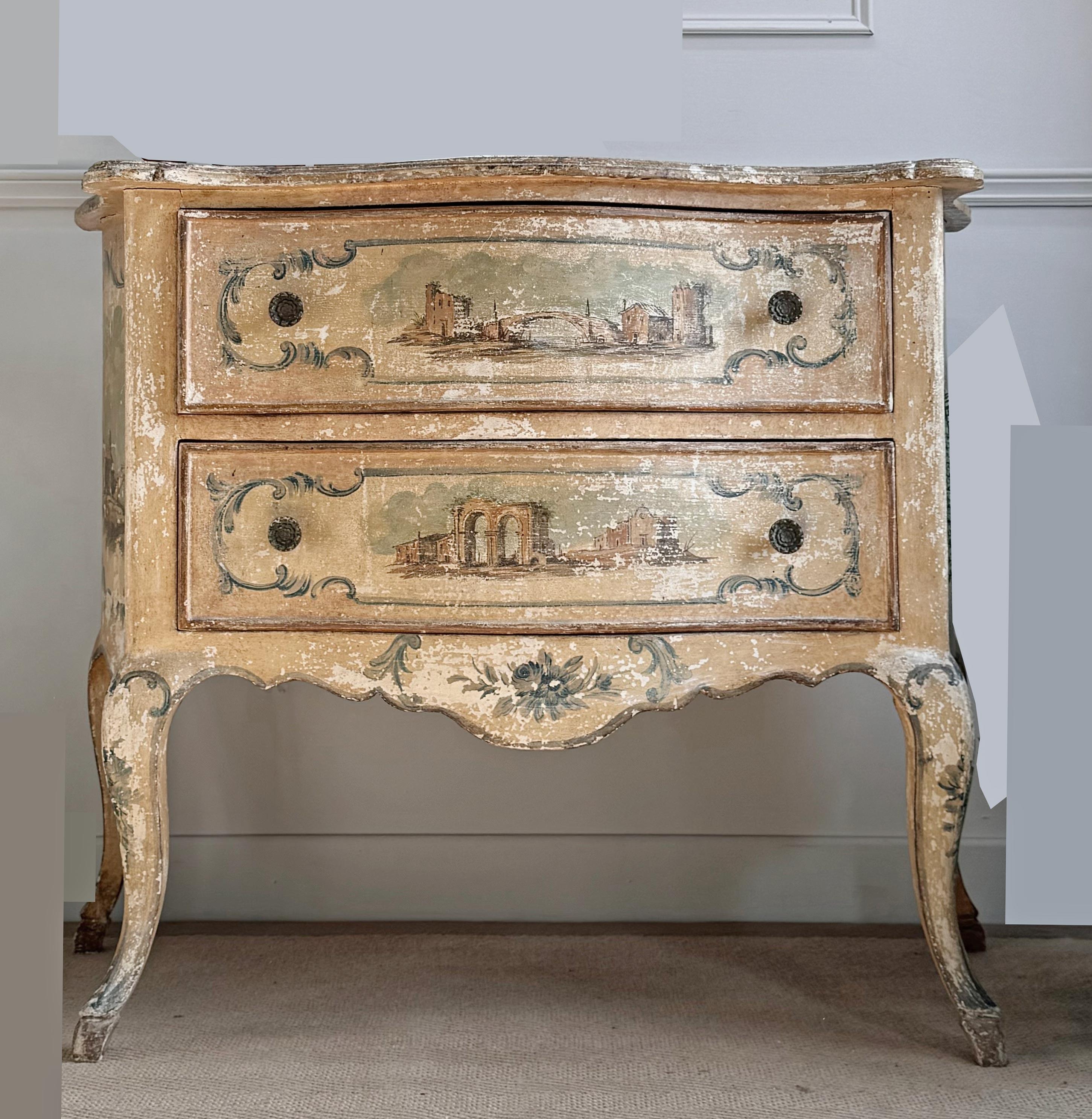 A beautiful and incredibly decorative Italian 18th century Venetian hand painted polychrome chest of drawers. The two drawer chest is raised upon elegant cabriole legs with hoof feet, with unique and captivating hand painted townscapes to each