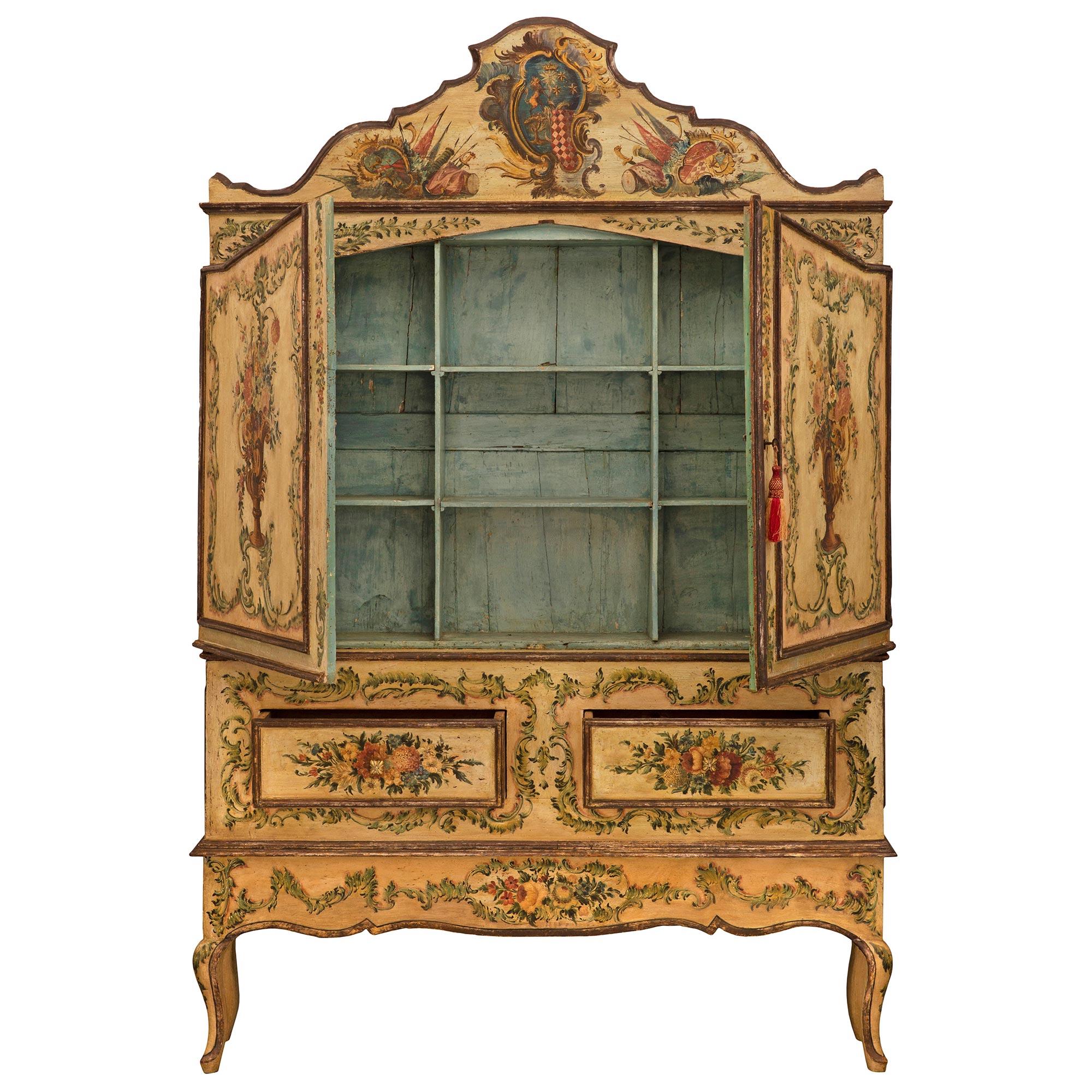 Un superbe et extrêmement décoratif cabinet vénitien du XVIIIe siècle, peint à la main. Ce meuble unique à deux portes et deux tiroirs repose sur d'élégants pieds cabriole et présente des fleurs épanouies peintes à la main de façon exceptionnelle et