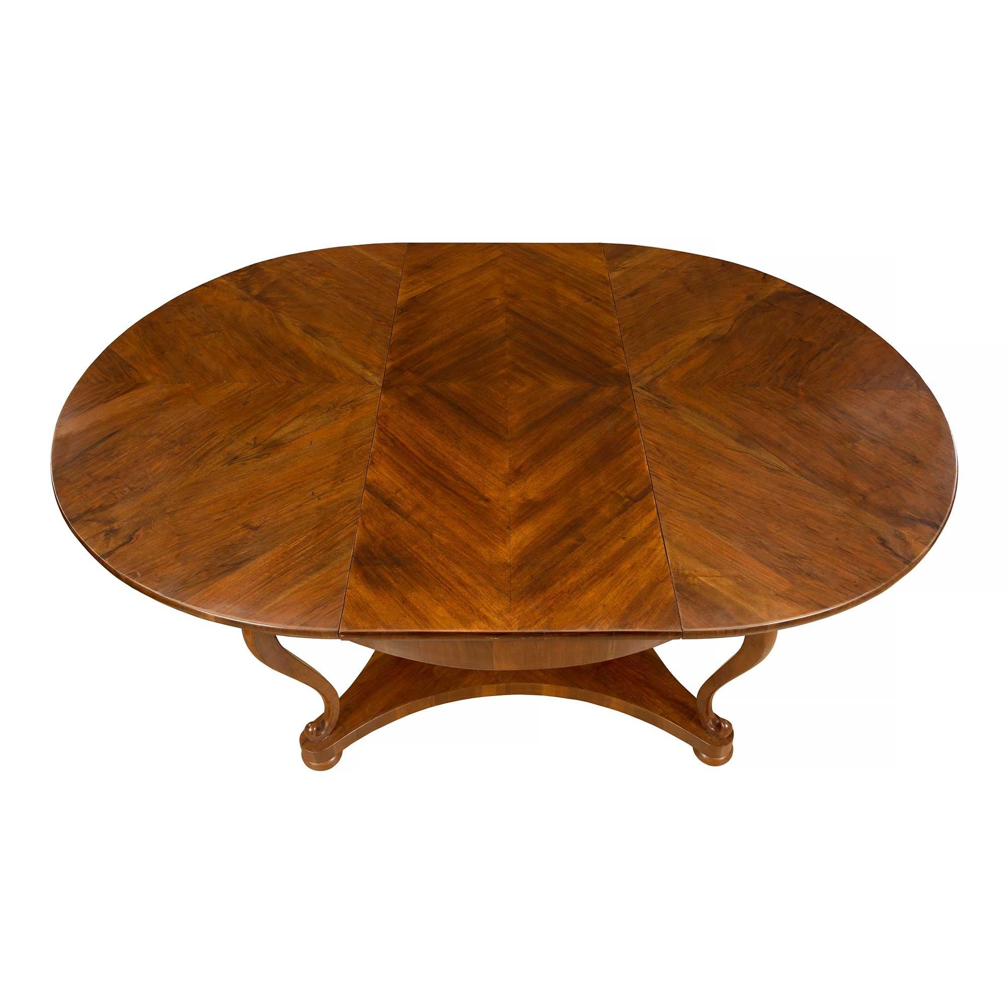 A lovely and unique Italian 18th-century walnut circular/oval center table from Northern Italy. The elegant table is raised on four bun feet below an X stretcher with concave sides and a quarter veneer pattern. Above are S scrolled cabriole legs