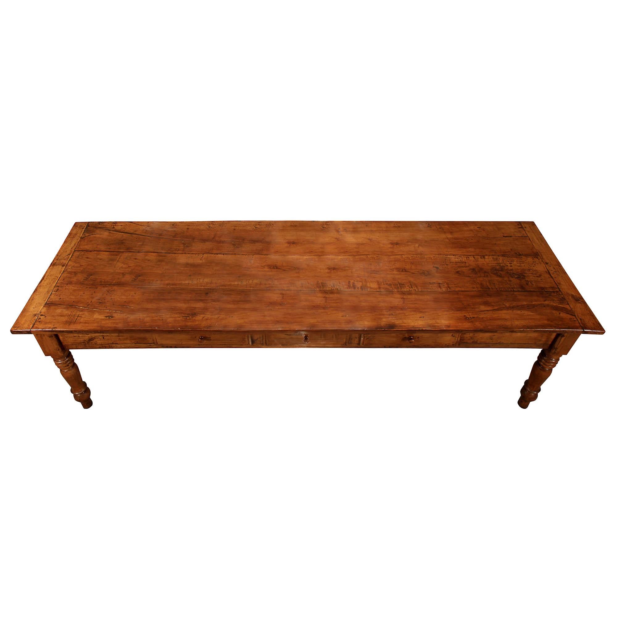 A very handsome and large scale Italian 18th century walnut country table. The table is raised on turned carved legs. At the straight frieze are three paneled drawers with walnut pulls. Above lays the walnut wonderful grain top. All original warm
