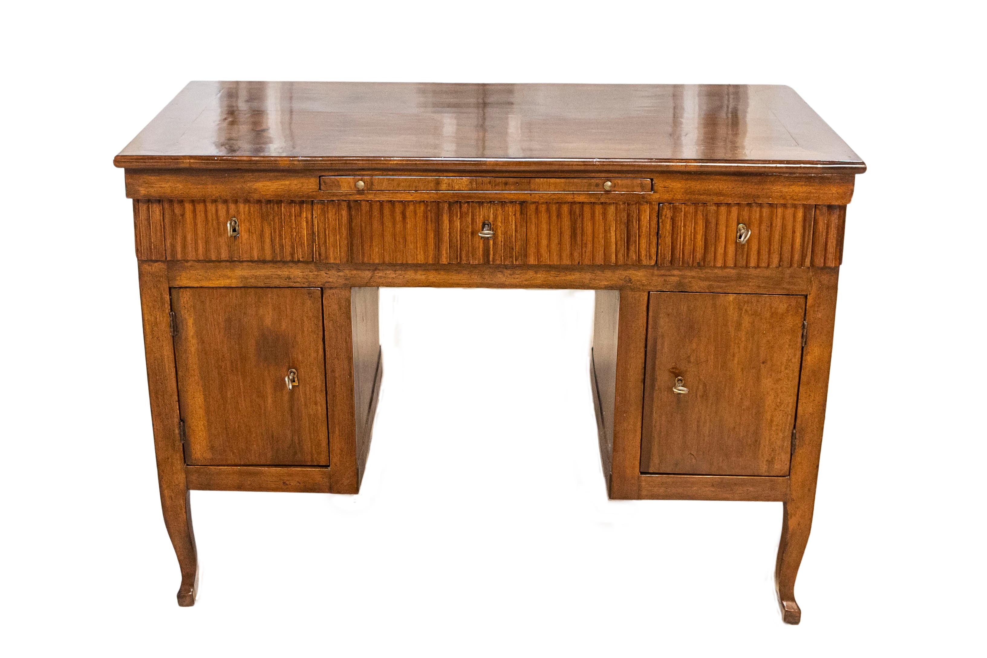 An Italian walnut desk from the 18th century with three drawers, pull-out, two doors and curving legs. This exquisite Italian walnut desk from the 18th century combines timeless style with functional elegance. It features three front drawers and two
