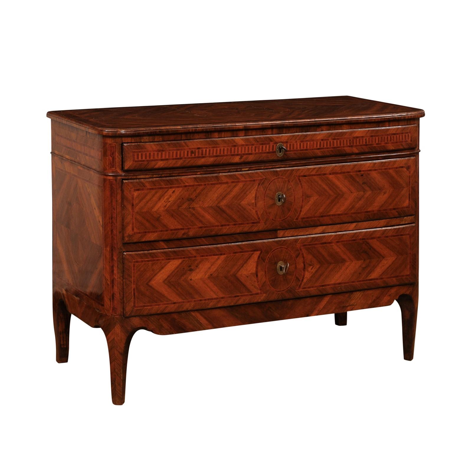 An Italian walnut, mahogany and cherry commode from the 18th century with three drawers and beautiful marquetry décor. Discover the timeless elegance of this exquisite Italian commode from the 18th century. Crafted from walnut, mahogany, and cherry