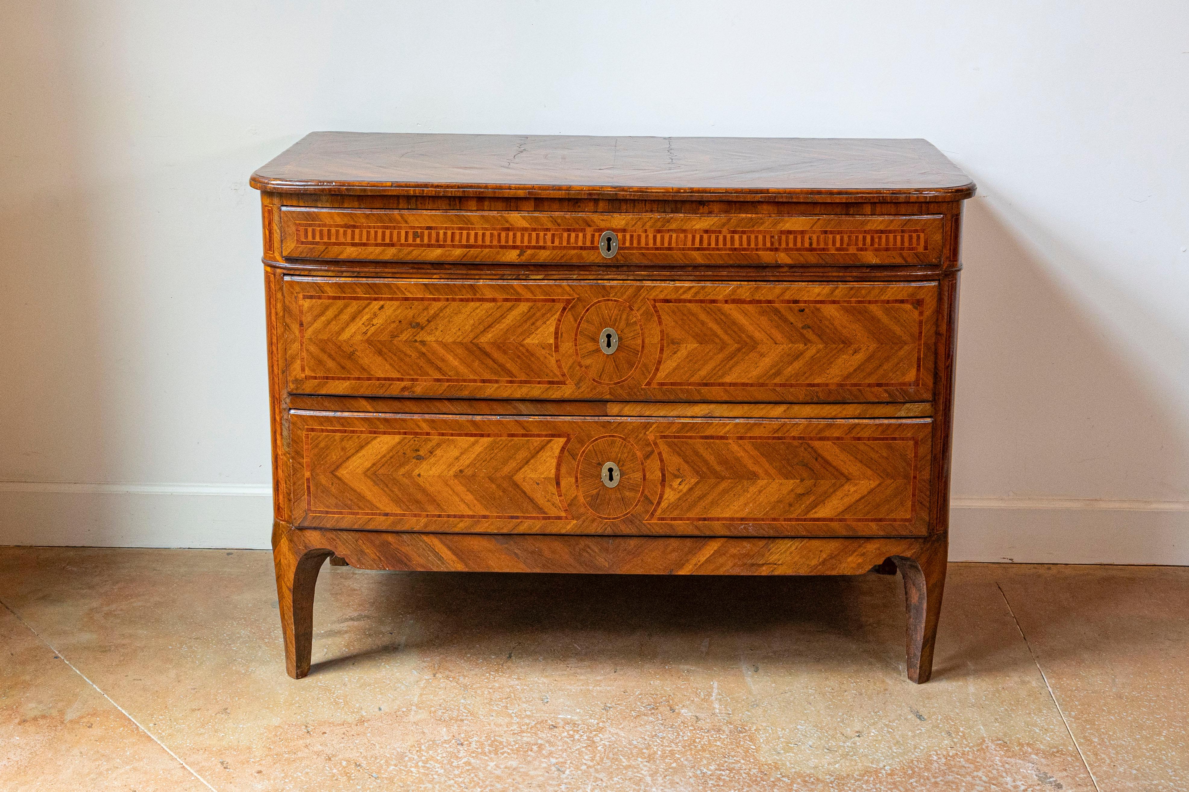 Cómoda italiana de nogal, caoba y cerezo del siglo XVIII con tres cajones y bella decoración de marquetería. Descubre la elegancia intemporal de esta exquisita cómoda italiana del siglo XVIII. Fabricada en madera de nogal, caoba y cerezo, esta