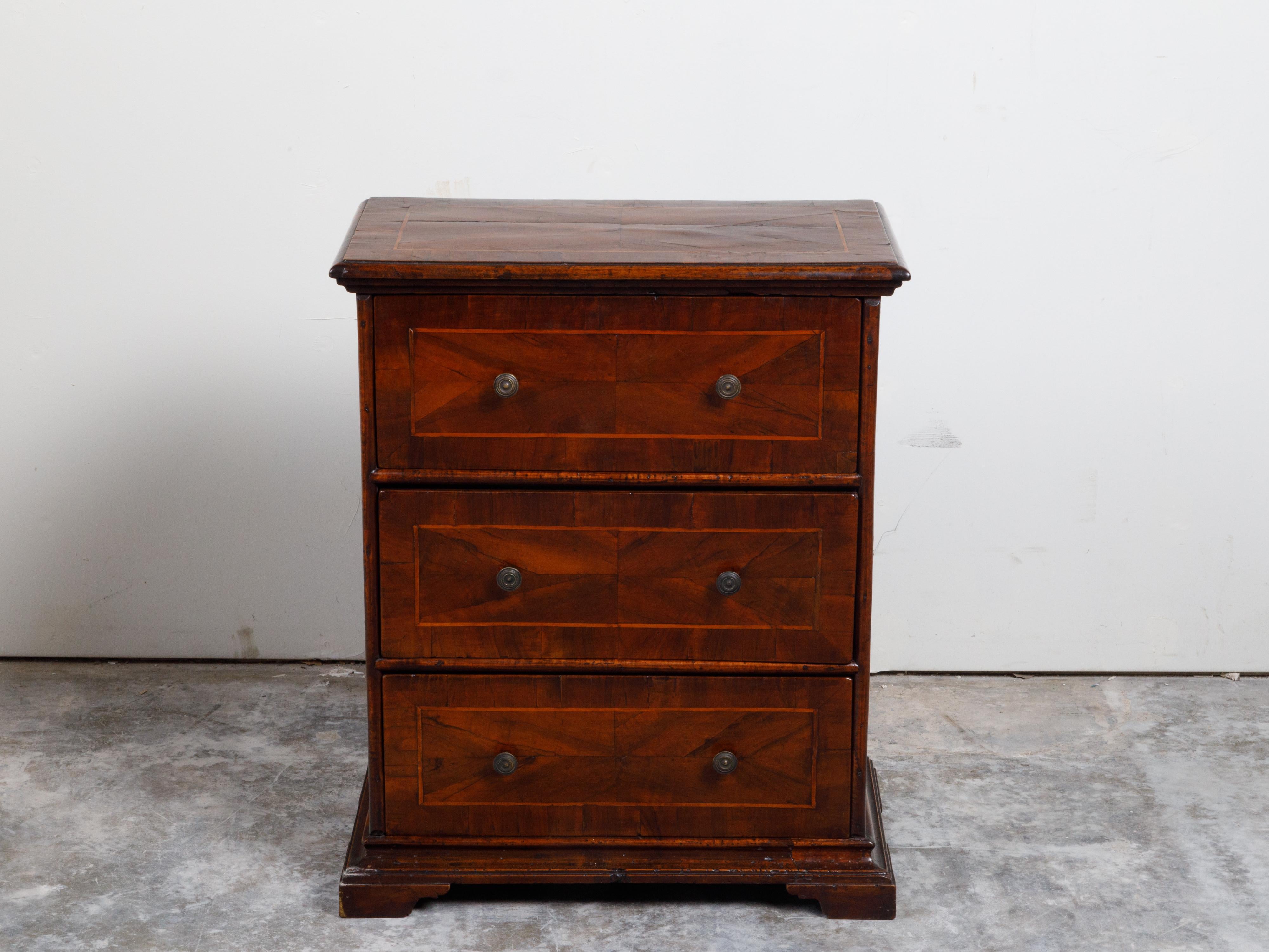 An Italian walnut commode from the 18th century, with three drawers, quarter veneer and banding. Created in Italy during the 18th century, this walnut commode features a rectangular top with quarter veneer and banding, sitting above three drawers