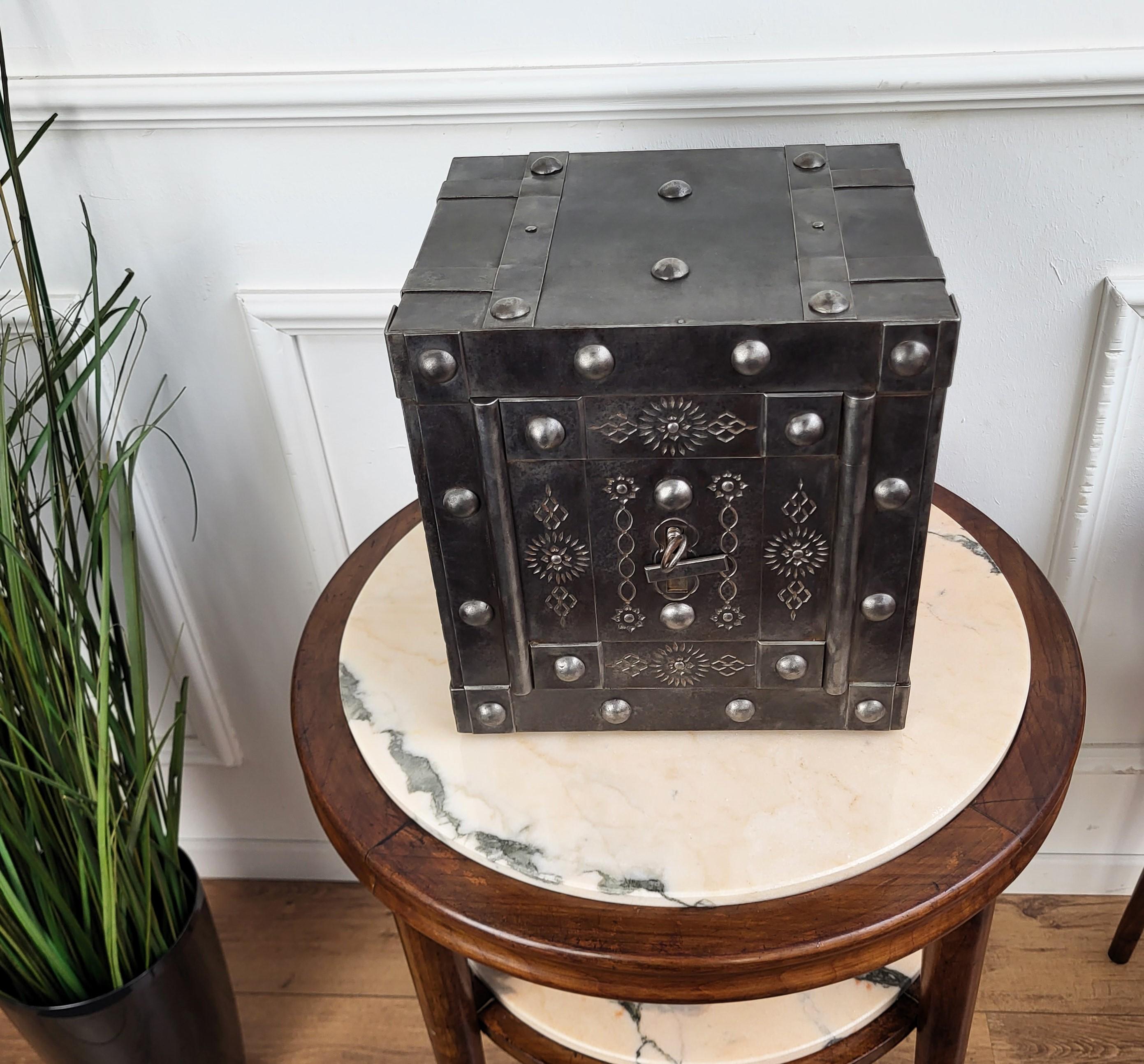 This beautiful Italian antique safe is a collector piece with typical all-around hobnails, dated circa 1820-1840, has a great metal color with patina of time and amazingly rich decorations, characterized by the central door with great burin