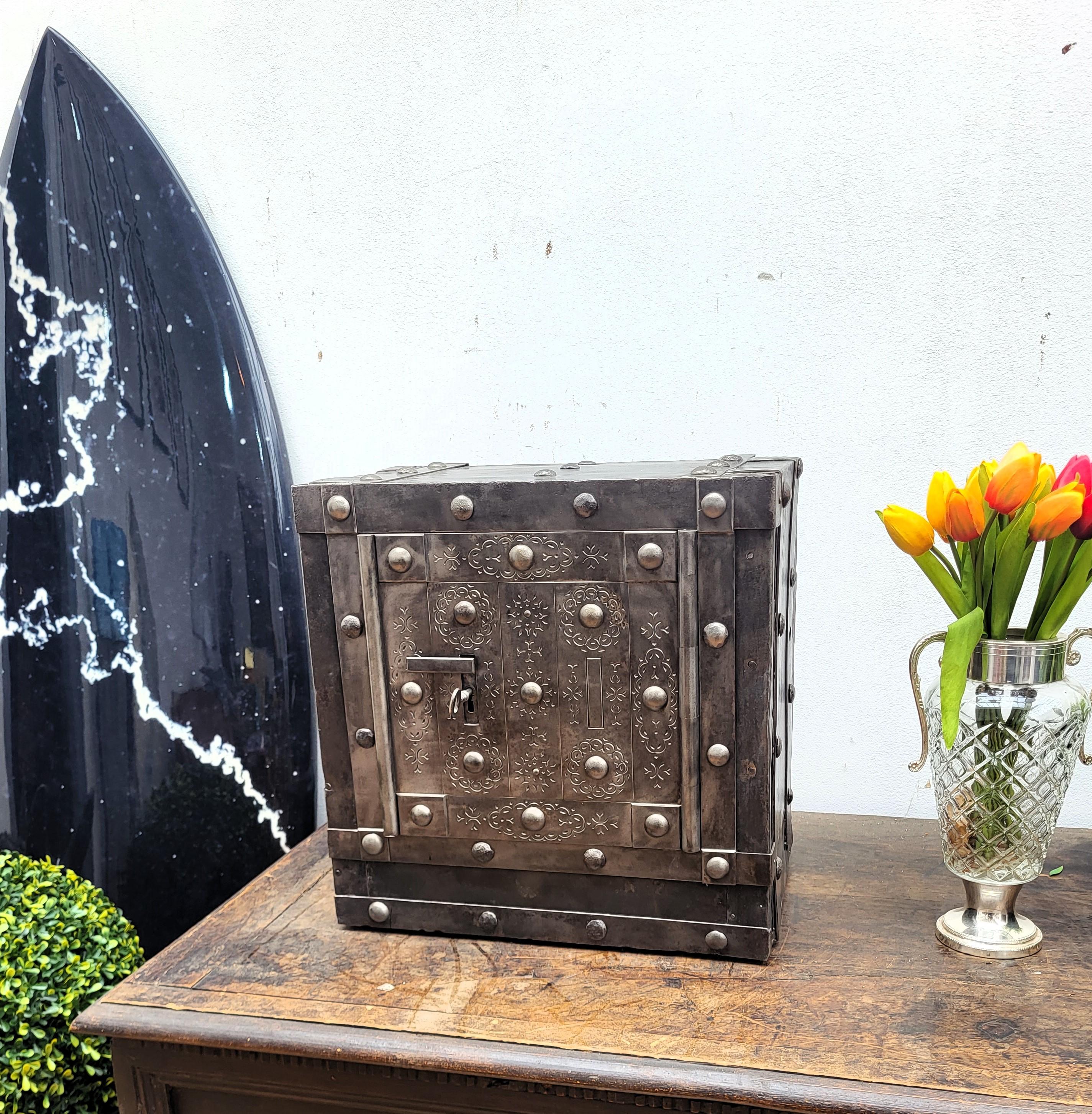 This beautiful Italian antique safe is a collector piece with typical all-around hobnails, dated circa 1820-1840, has a great metal color with patina of time and amazingly rich decorations, characterized by the central door with great burin