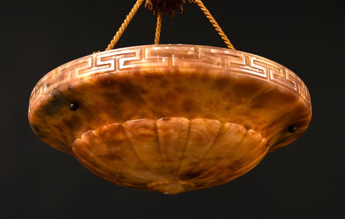 1920s alabaster bowl form light fixture with Greek key carved frieze and lobe carving. The alabaster bowl hung from a silken and tasseled rope.