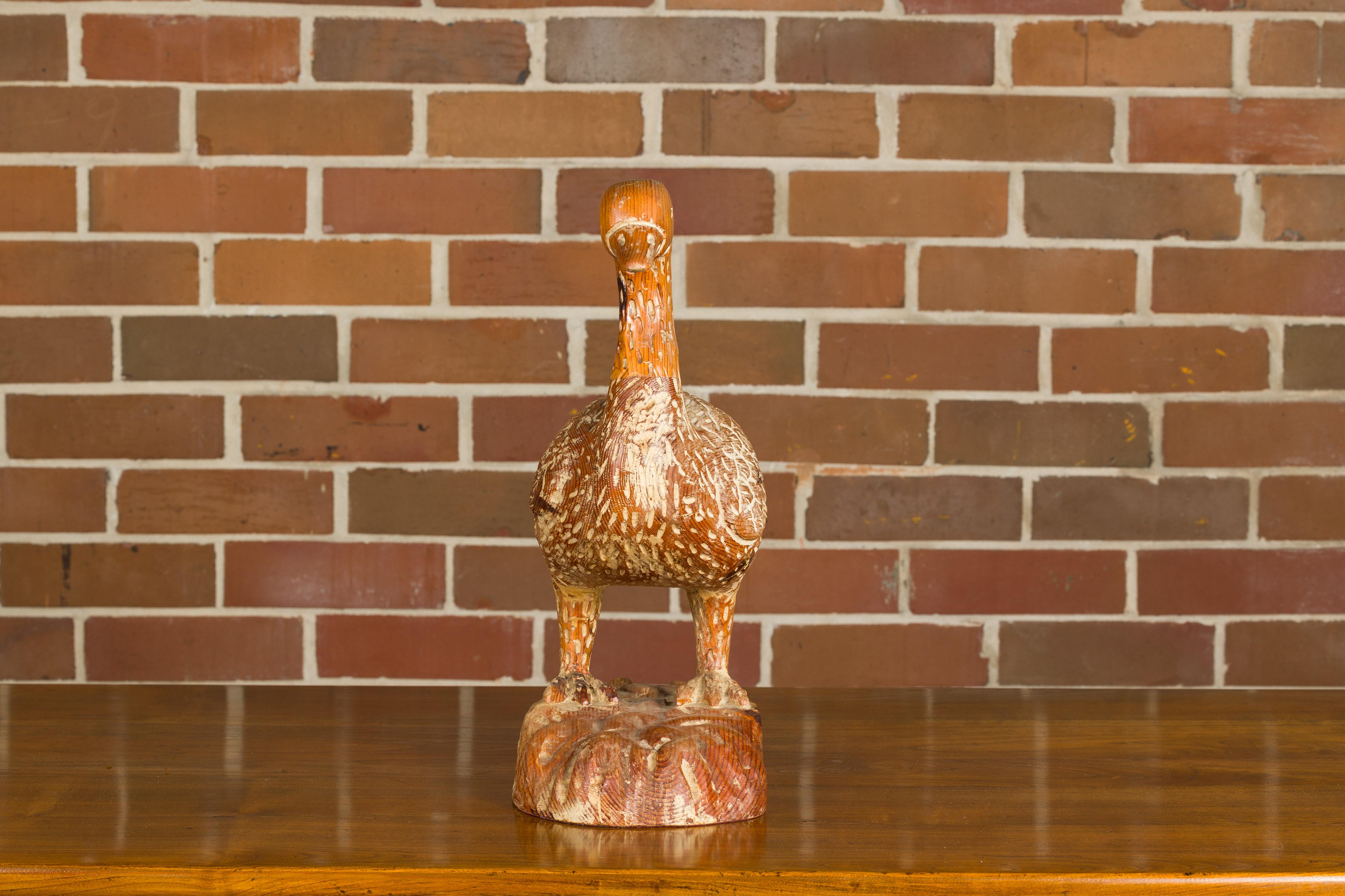 An Italian carved wooden duck sculpture from circa 1920 with light painted accents and textured base. Enhance your living space with the timeless charm of this Italian carved wooden duck sculpture, dating back to circa 1920. Crafted with artistry,