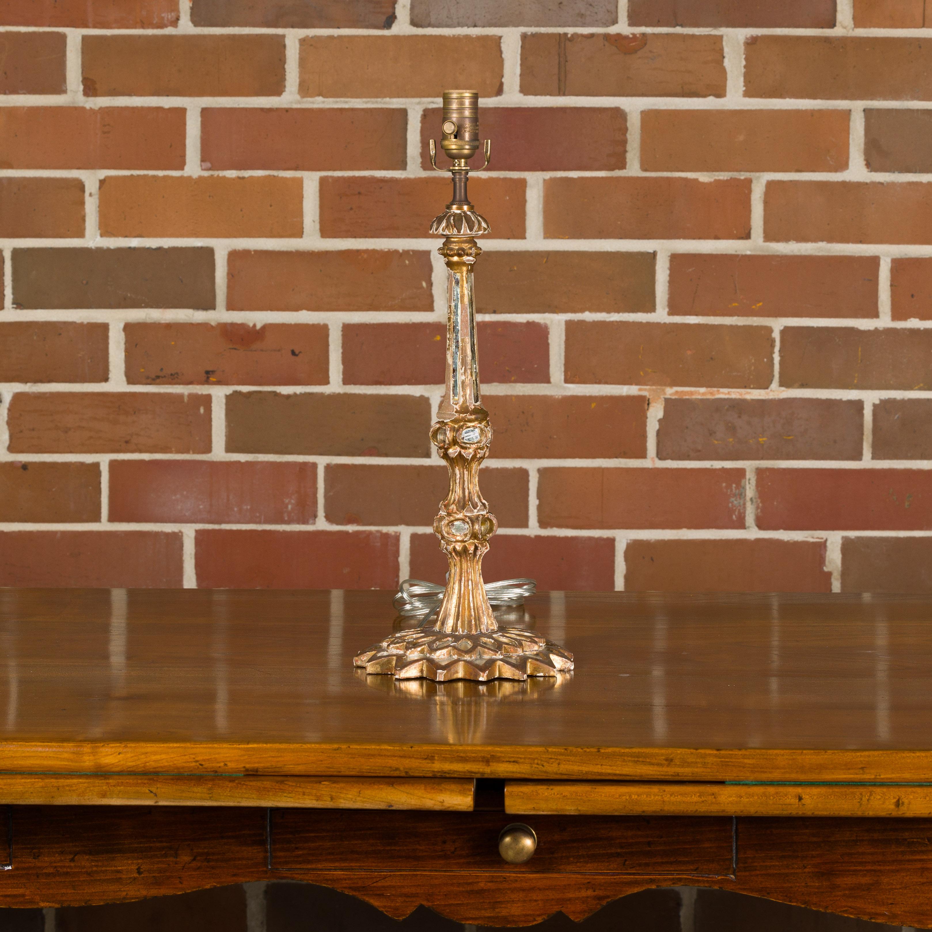 Lampe de table italienne en bois sculpté et doré, datant de 1920 environ, avec des miroirs encastrés et une base rayonnante en forme de soleil. Laissez-vous séduire par l'allure opulente de cette lampe de table italienne en bois sculpté et doré,