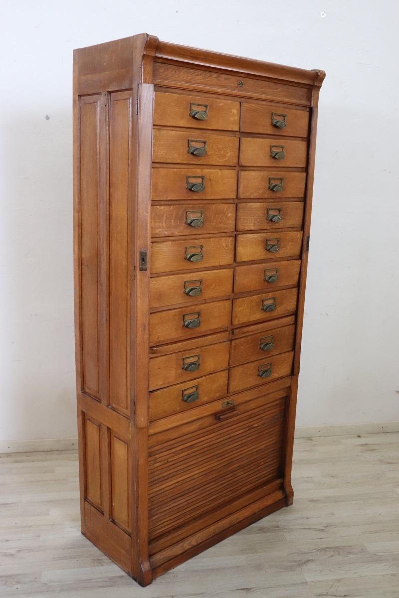 We offer this unique Italian filing cabinet from the 1920s, crafted from solid oak. The top features the original label from the manufacturer in Genoa (northern Italy).

This fantastic cabinet, designed for office use, has a distinctive design and a