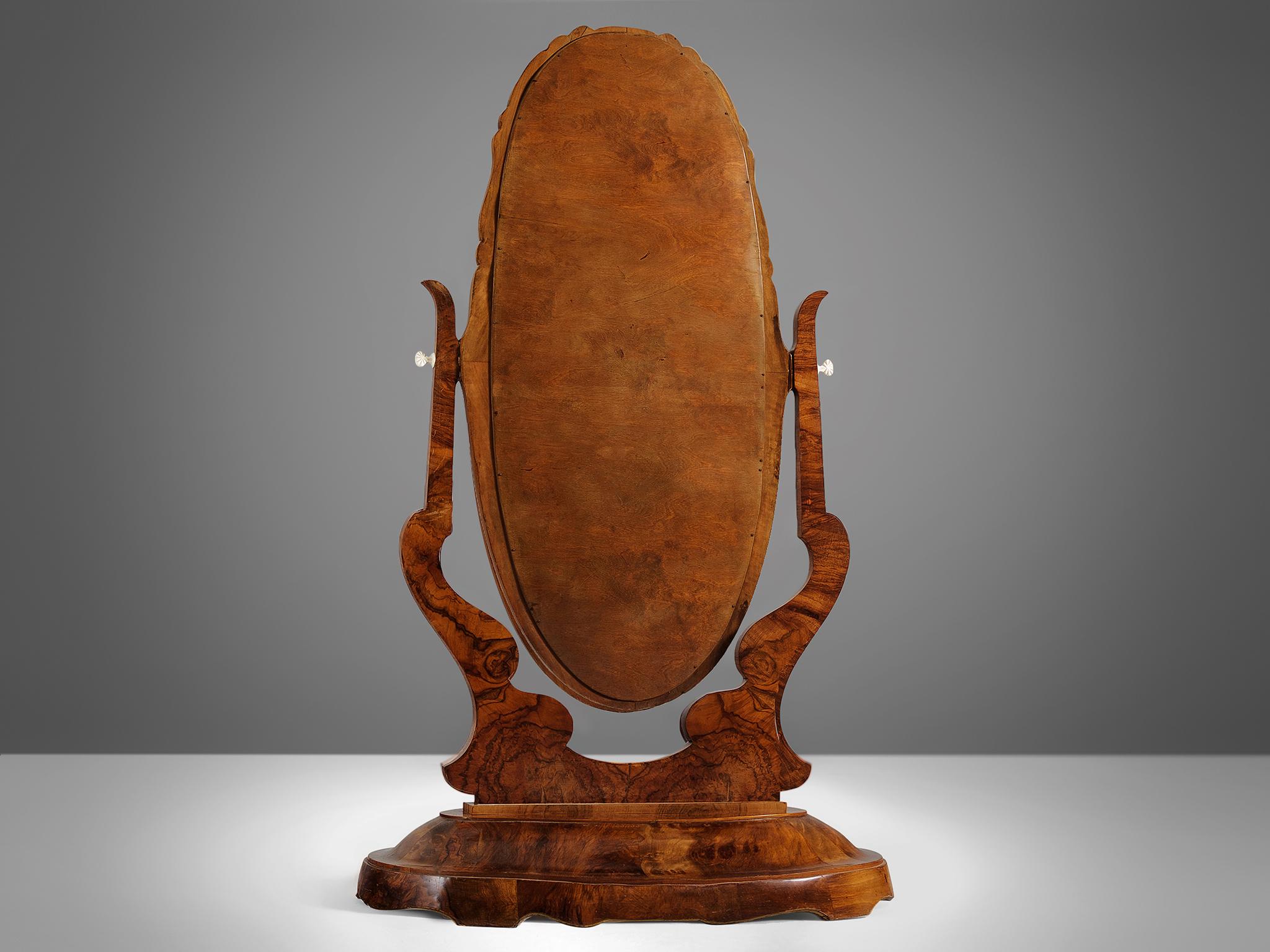 Dressing mirror, mahogany, Italy, 1930s.

Impressive and elegant dressing Italian mirror Italy. The veneer shows a wonderful grain and the mahogany details are shaped to perfection. The oval mirror is adjustable for easy use. The decorative shapes