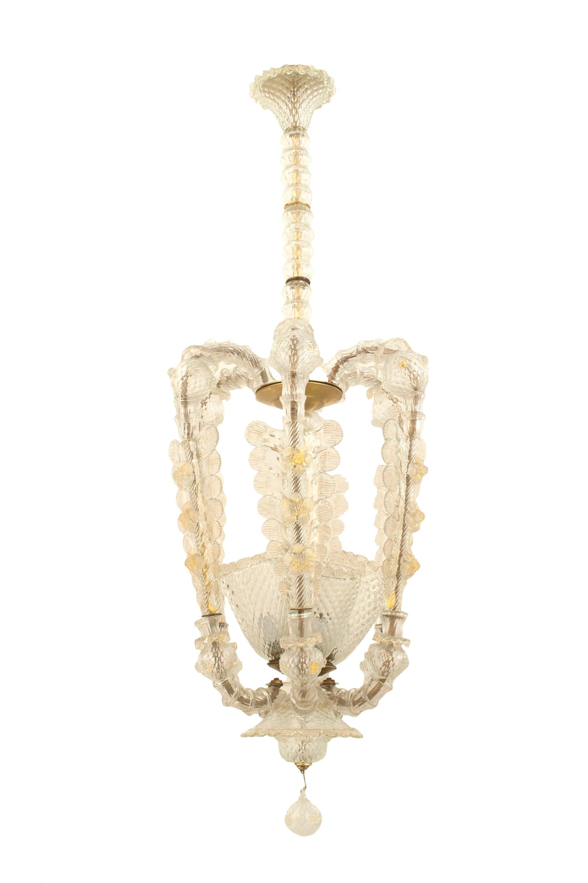 Italian Art Deco clear glass lantern form chandelier with 4 internal uplight shades surrounded by 6 feather supports suspended by a spool shaft & final ball bottom (BAROVIER & TOSO), circa 1935.


Barovier e Toso is a renowned Venetian company