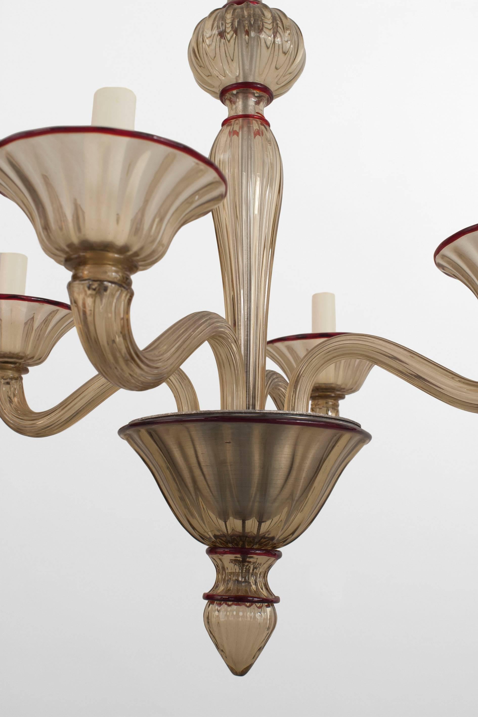 Italian 1940s amber glass chandelier with four arms emanating from a tiered centre post and cup bobeches with applied red glass trim (by Venini).

 
