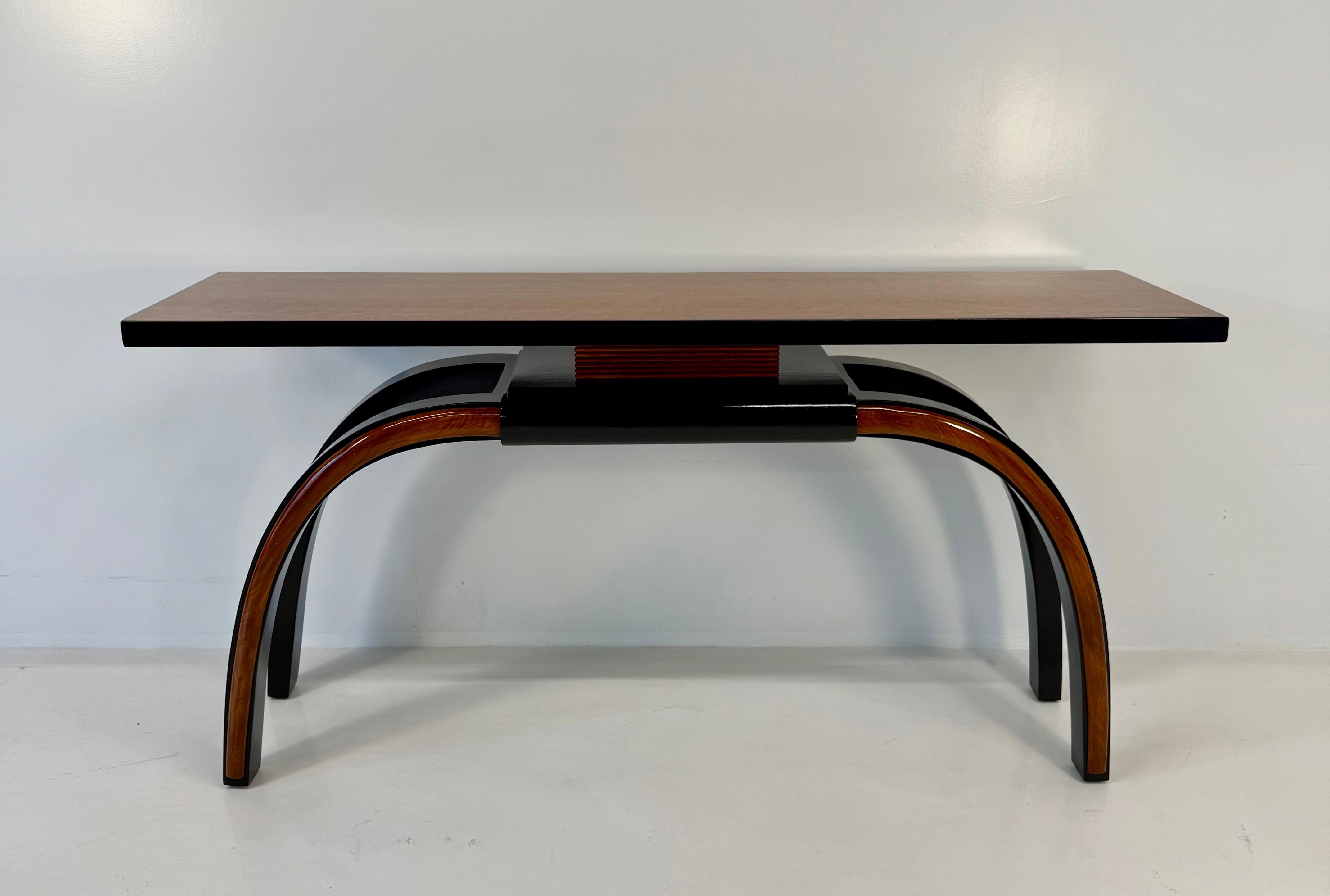 Elegant Italian Art Deco console, 1940s.
The structure is finished in glossy black lacquer, enriched by solid walnut profiles that add warmth and contrast. The top features maple burl veneer, with natural patterns creating a refined and luminous