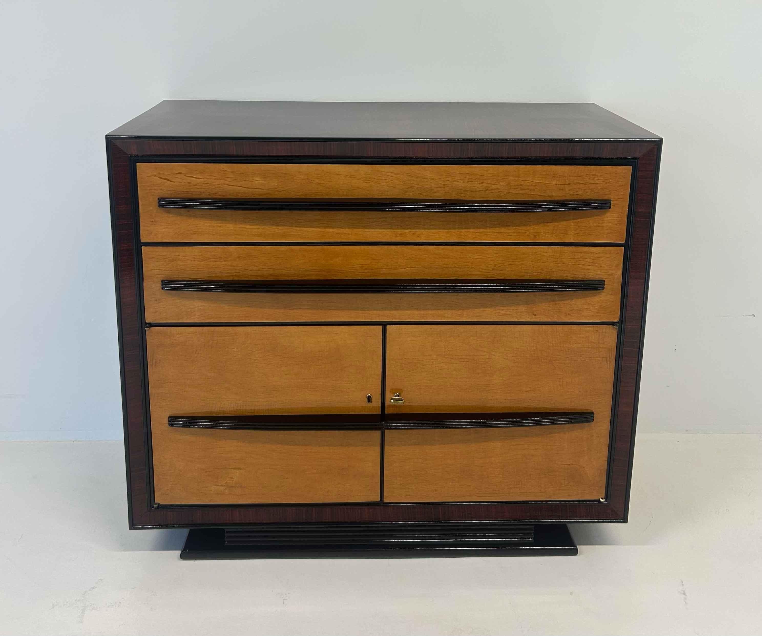 Commode Art déco italienne raffinée des années 1940, attribuée à Osvaldo Borsani. La structure en érable s'associe magnifiquement aux détails en bois noir ébonisé, créant un contraste élégant et sophistiqué.
Les lignes épurées et les proportions