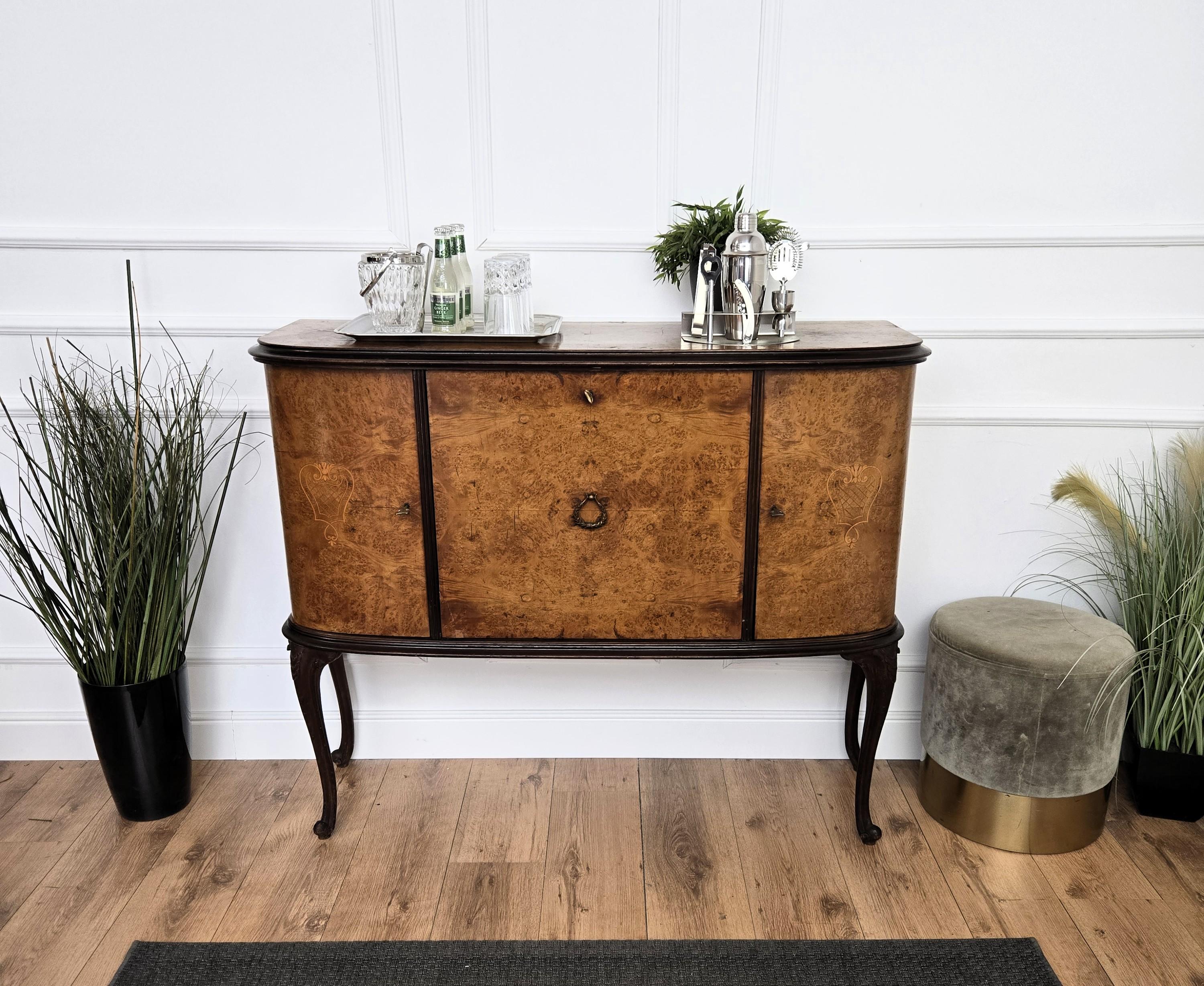 Elegantissimo mobile bar in stile Art Deco Mid-Century Modern, con bella impiallacciatura in radica di noce, tre ante, 4 gambe intagliate, maniglie e chiavi in ottone. Quando viene aperta, a sinistra e a destra si trova un'incredibile parte interna