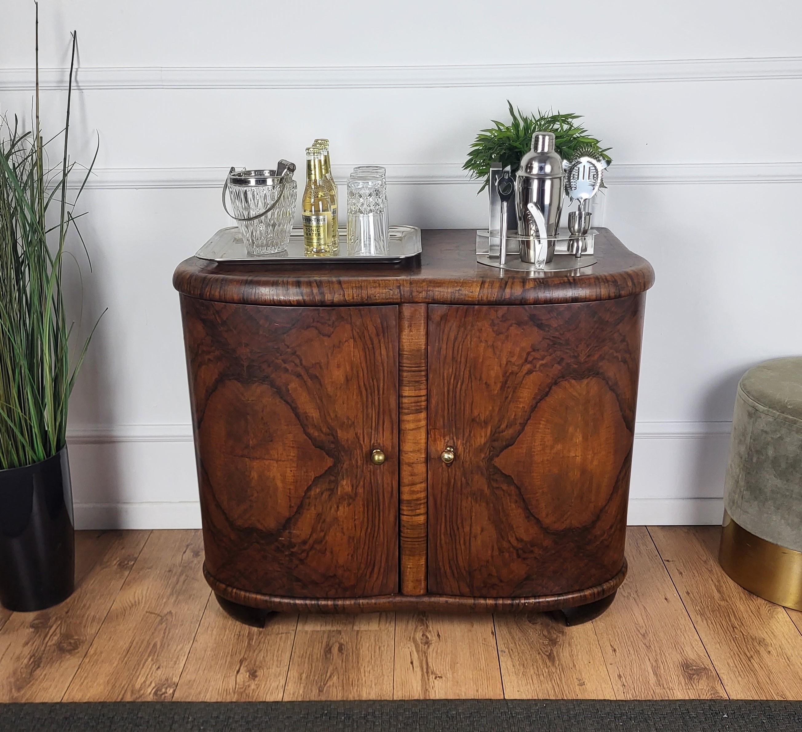 Very elegant Italian Art Deco Mid-Century Modern drinks dry bar cabinet with beautiful veneer walnut briar burl wood, two doors and great central wooden decor craftmanship and brass handles. When opened, on the right side an amazing interior part in