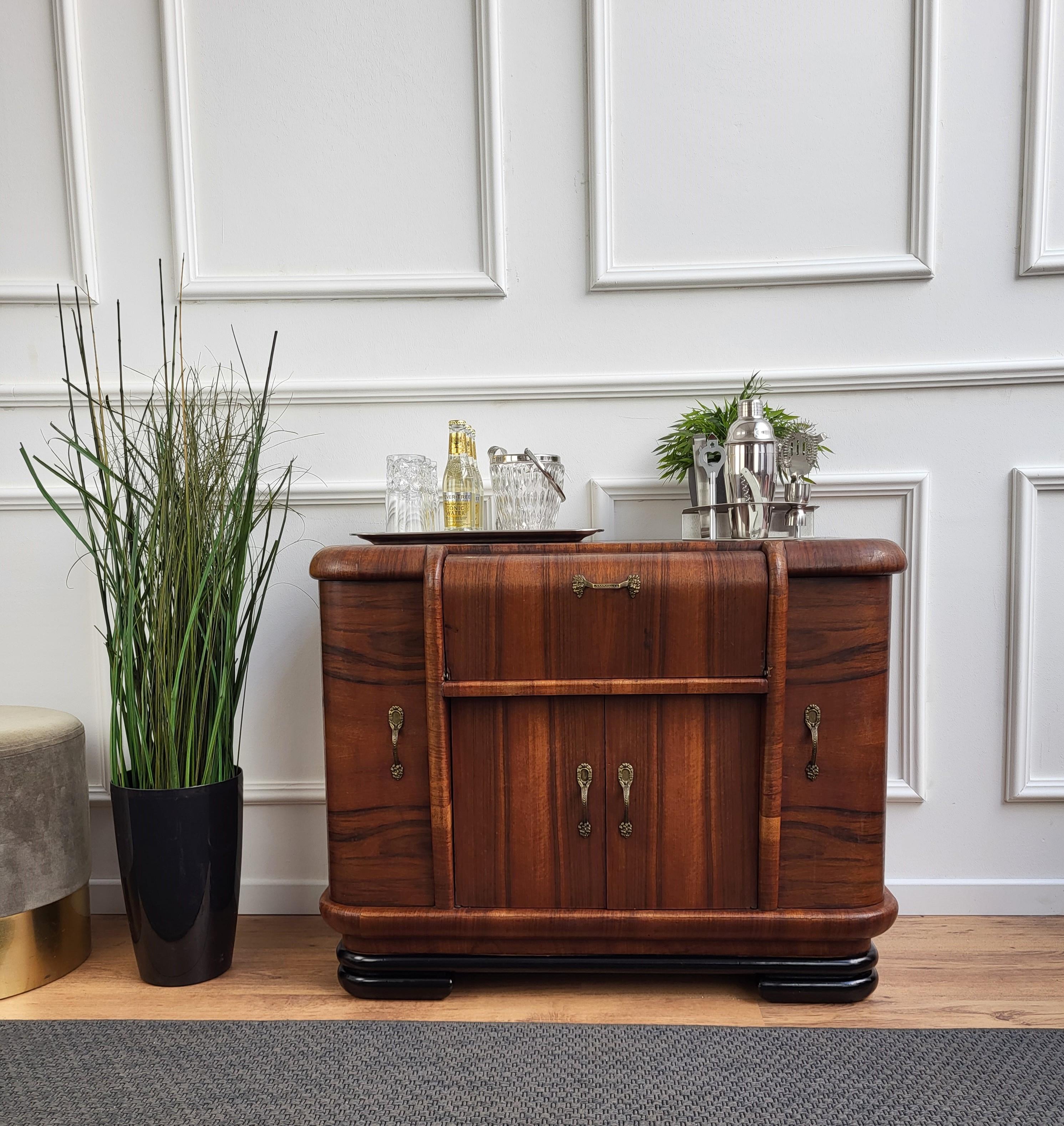 Very elegant Italian Art Deco Mid-Century Modern drinks dry bar cabinet with beautiful veneer walnut briar burl wood, two side doors and two sentral compartments with great wooden decor craftmanship and brass handles. 
When opened, on the right and
