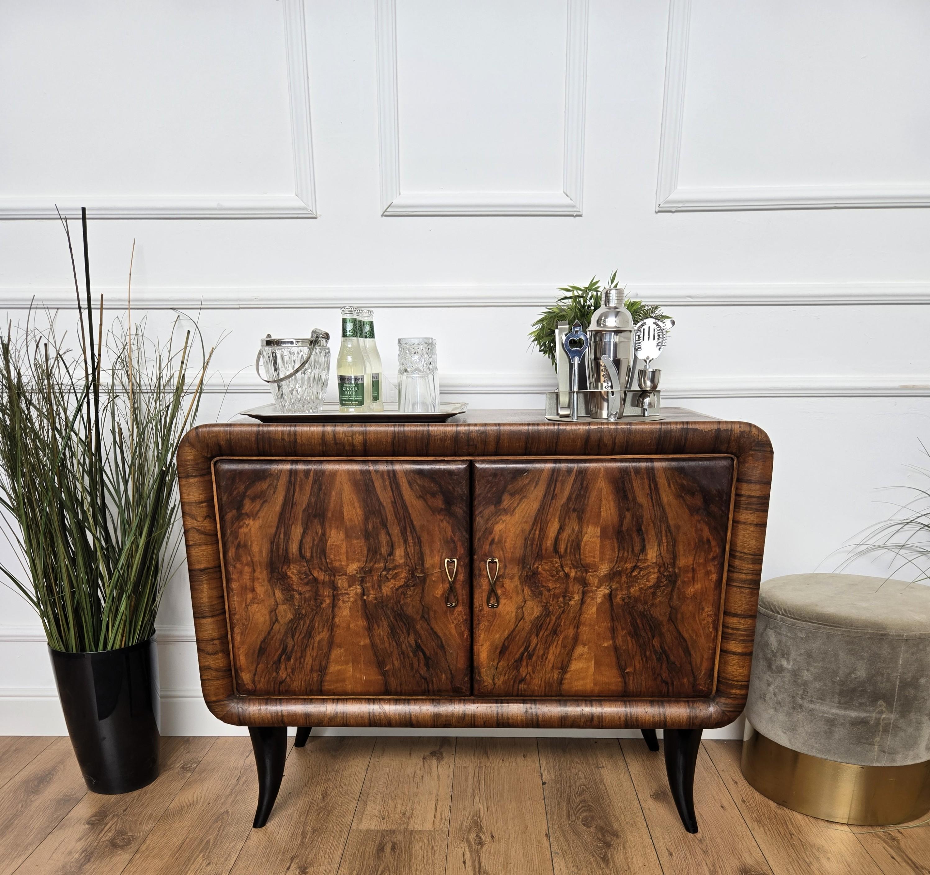Elegante mueble bar italiano Art Decó de mediados de siglo, de madera de nogal chapada, con dos puertas y tiradores de gran calidad. Cuando se abre, en el lado derecho hay un interior de mosaico de espejos destinado al espacio para botellas de